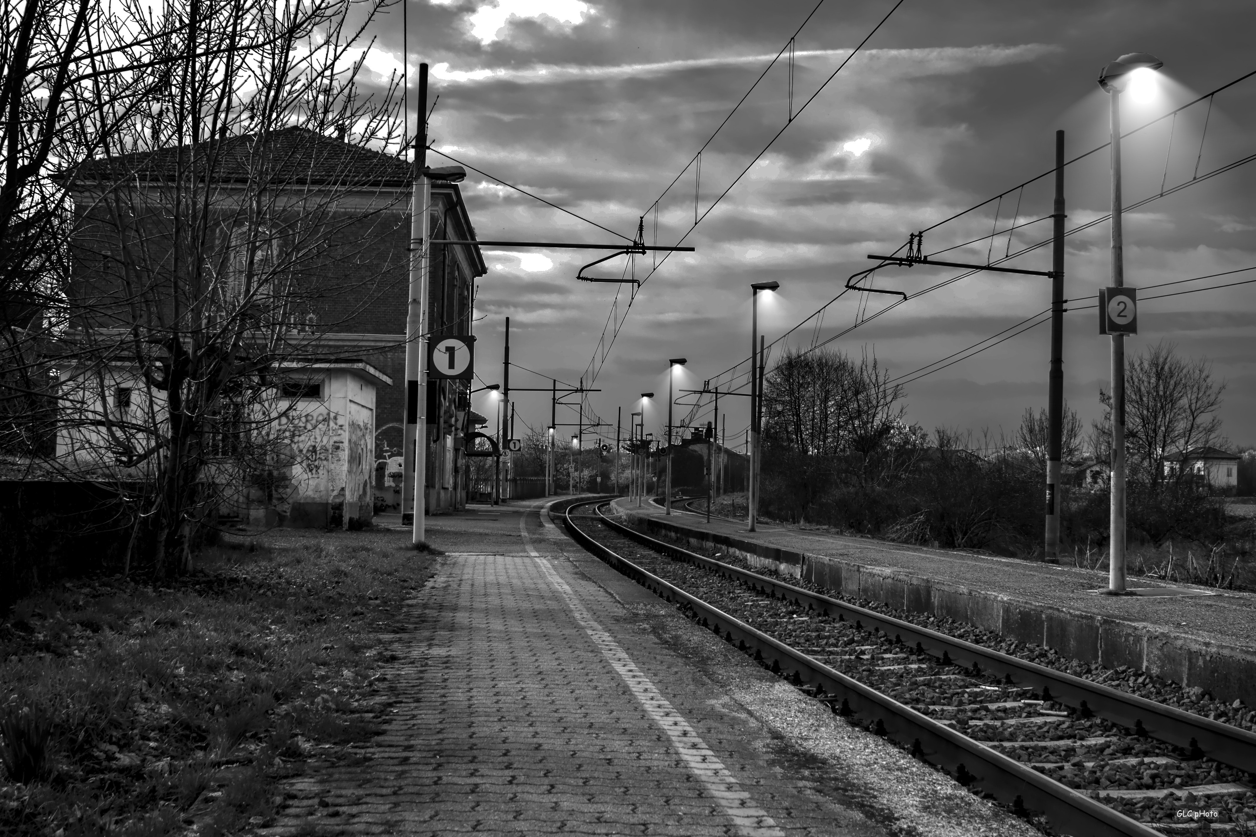 Railroad tracks by bare trees against sky photo