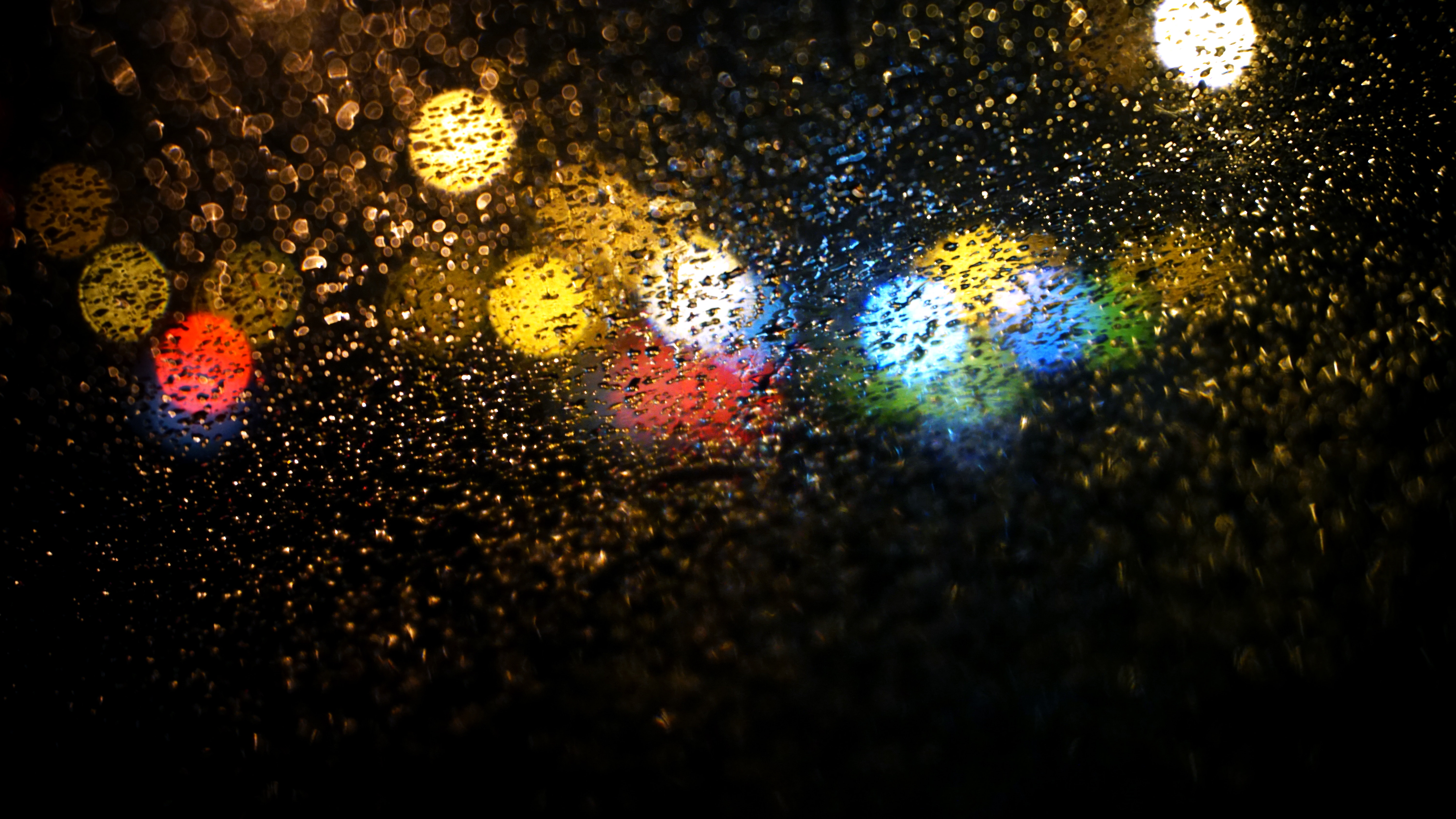 Raindrops on road seen through car window photo