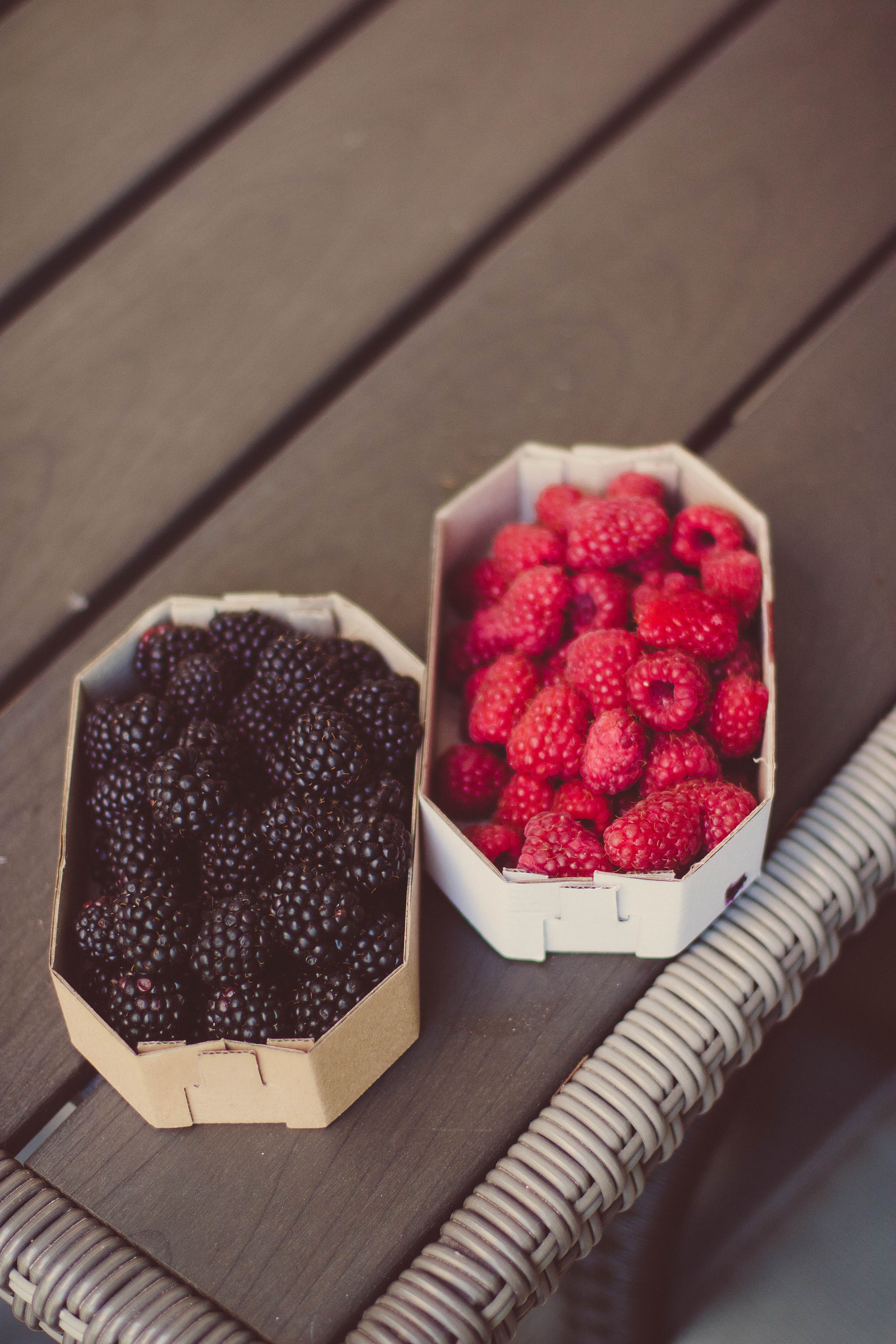 Raspberries and blueberries on top of table photo