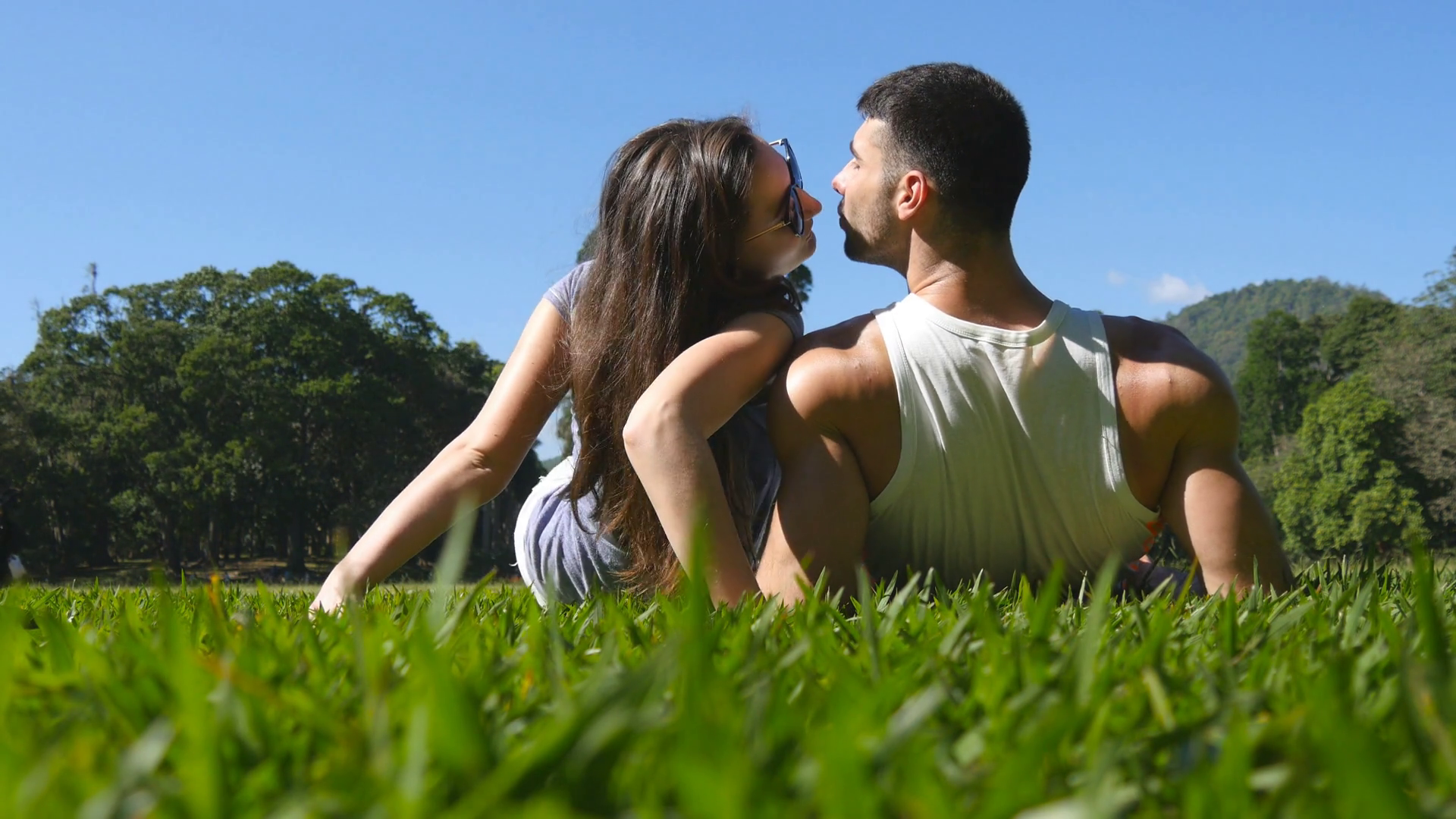 Young couple lying on green grass in park and relaxing. Man and ...