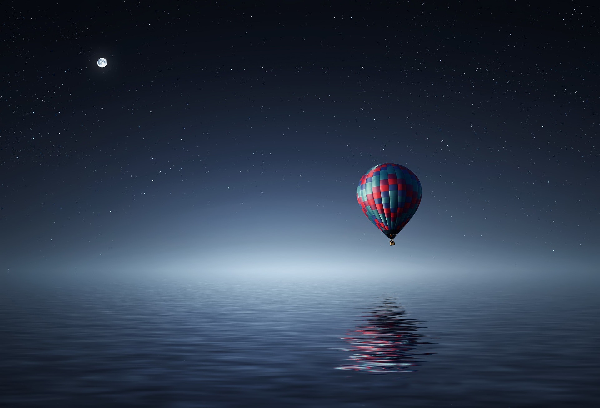 Red and blue hot air balloon floating on air on body of water during night time photo