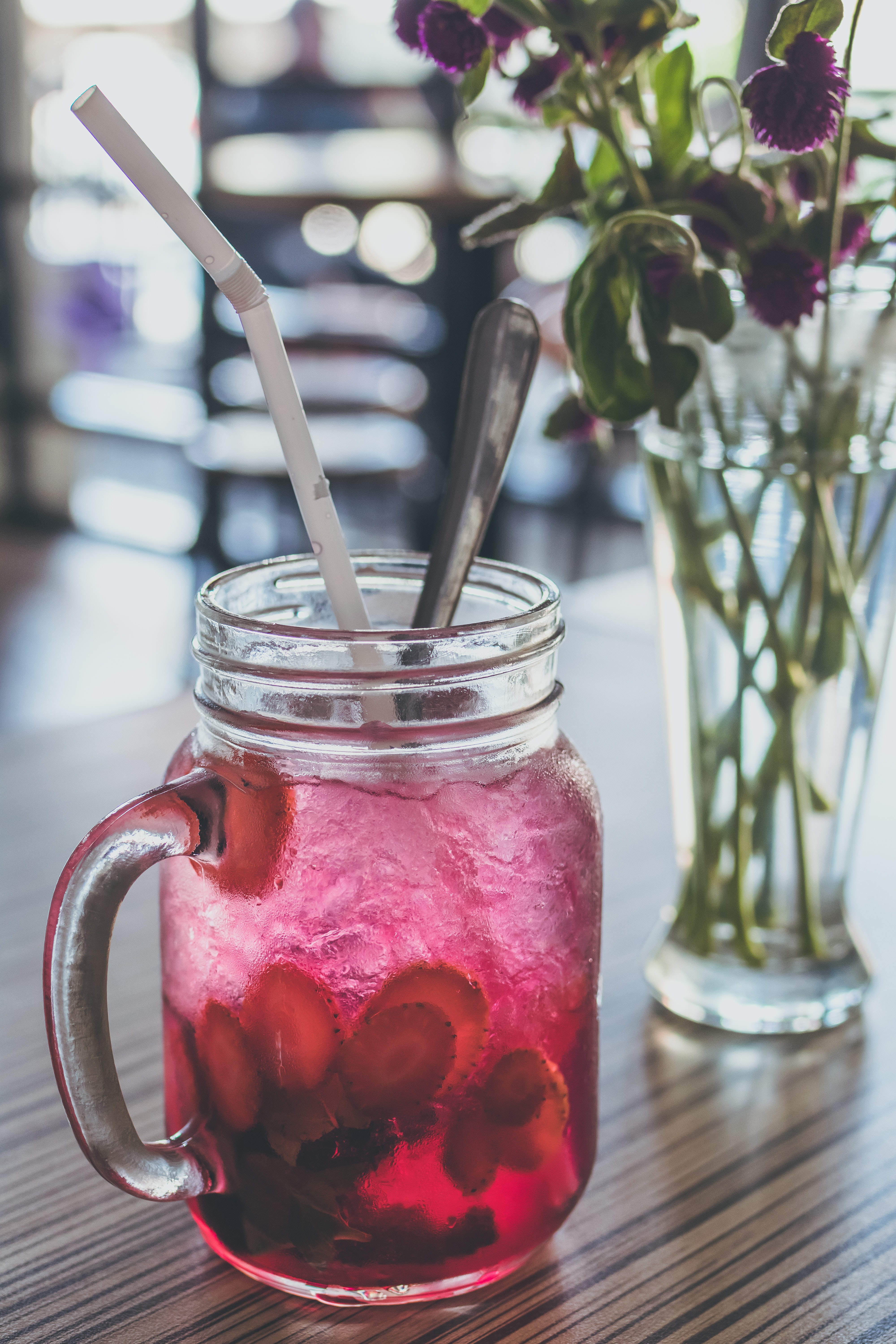 Red Beverage-filled Clear Glass Mason Mug With Straw Beside Purple Flowers in Vase, Alcohol, Ice, Ingredient, Jar, HQ Photo