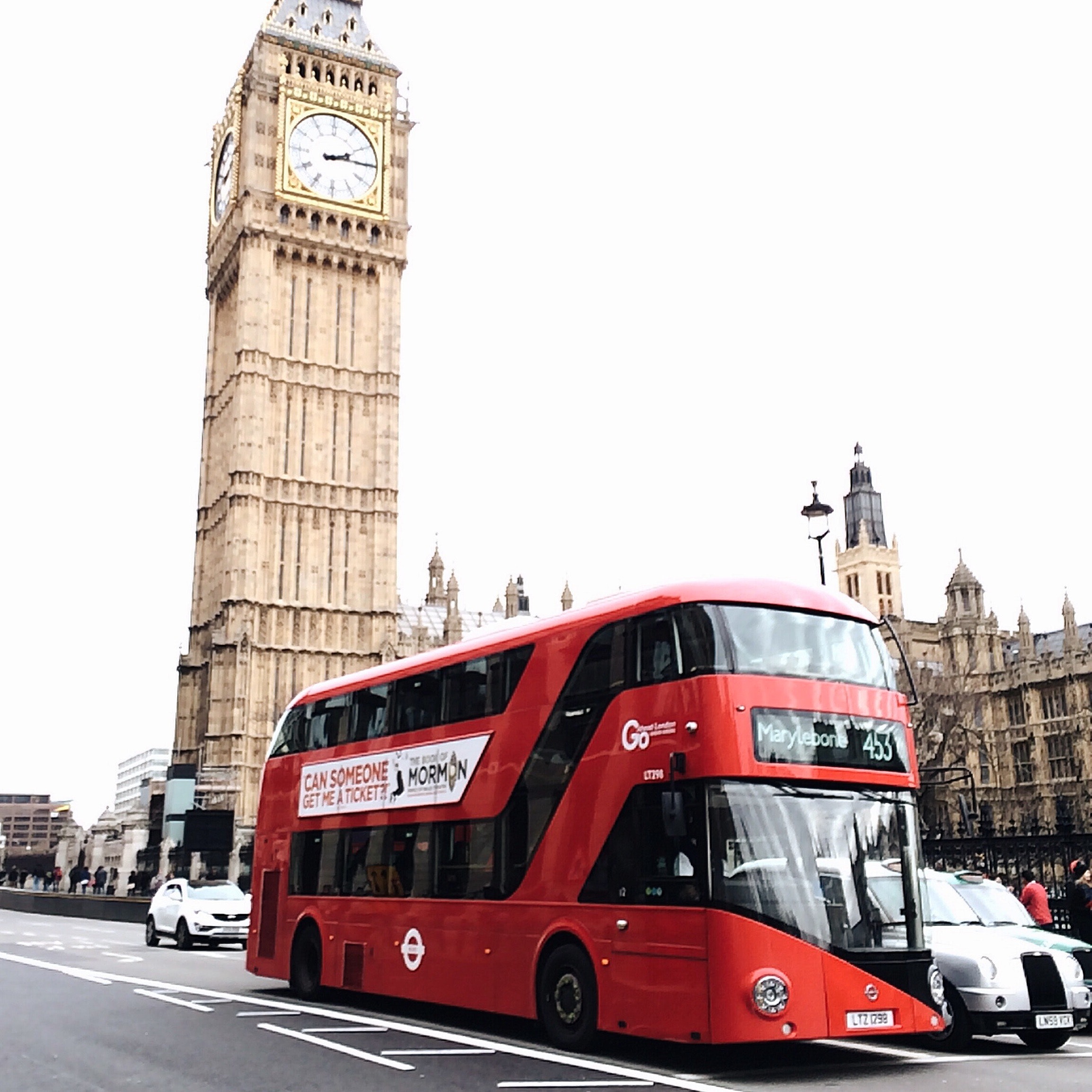 Red bus on road near big ben in london photo