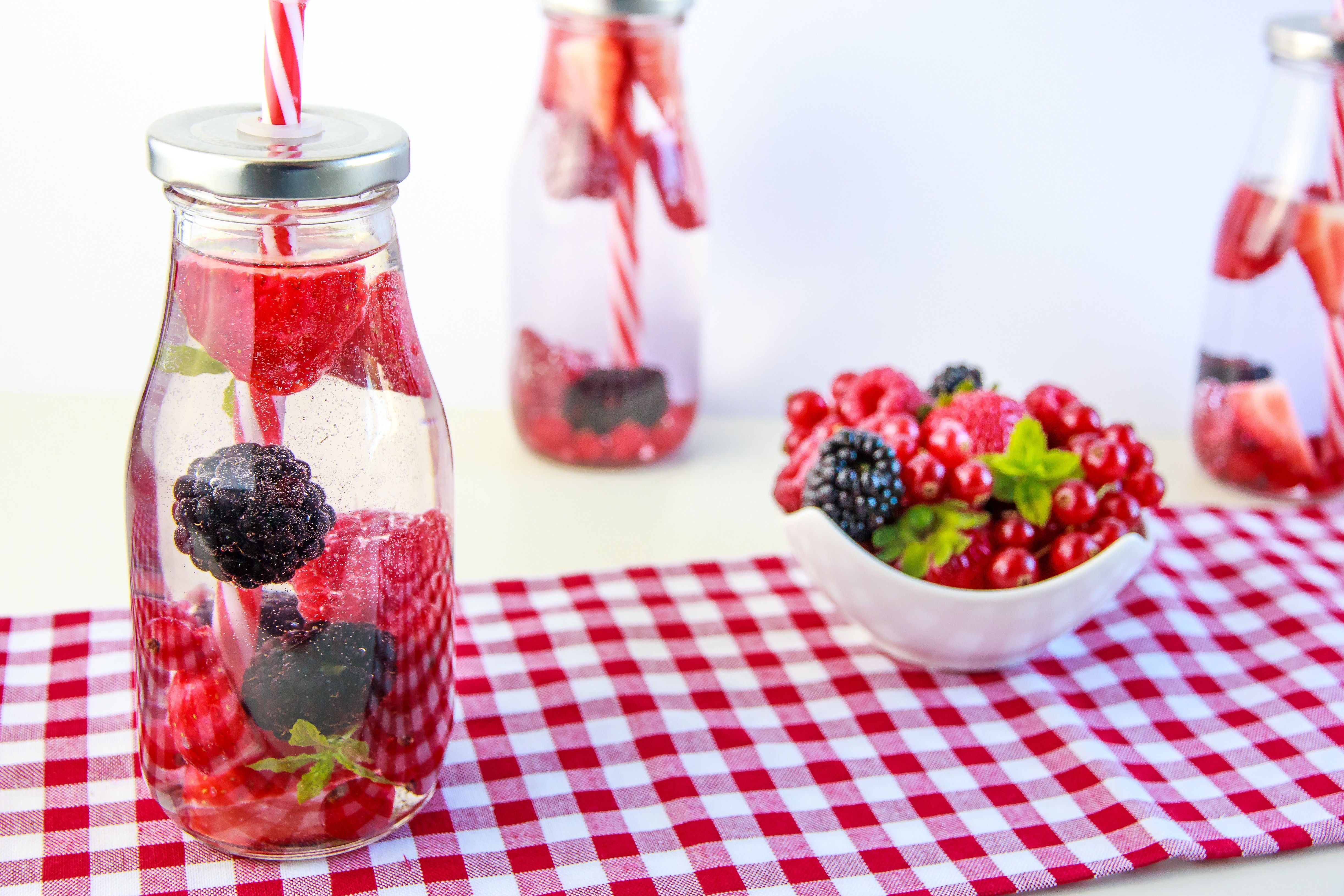 Red cherry and grapes on clear glass bottle photo