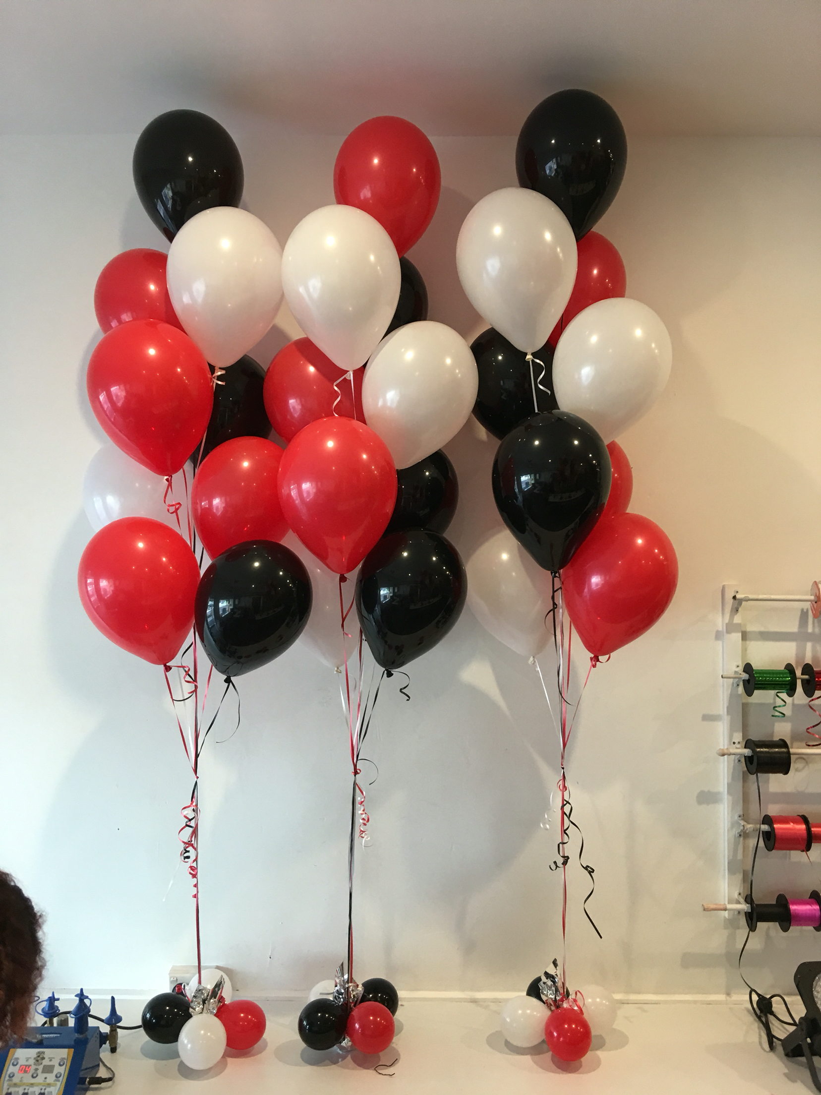 Bunches of black, red, white helium balloons in foyer (top and ...