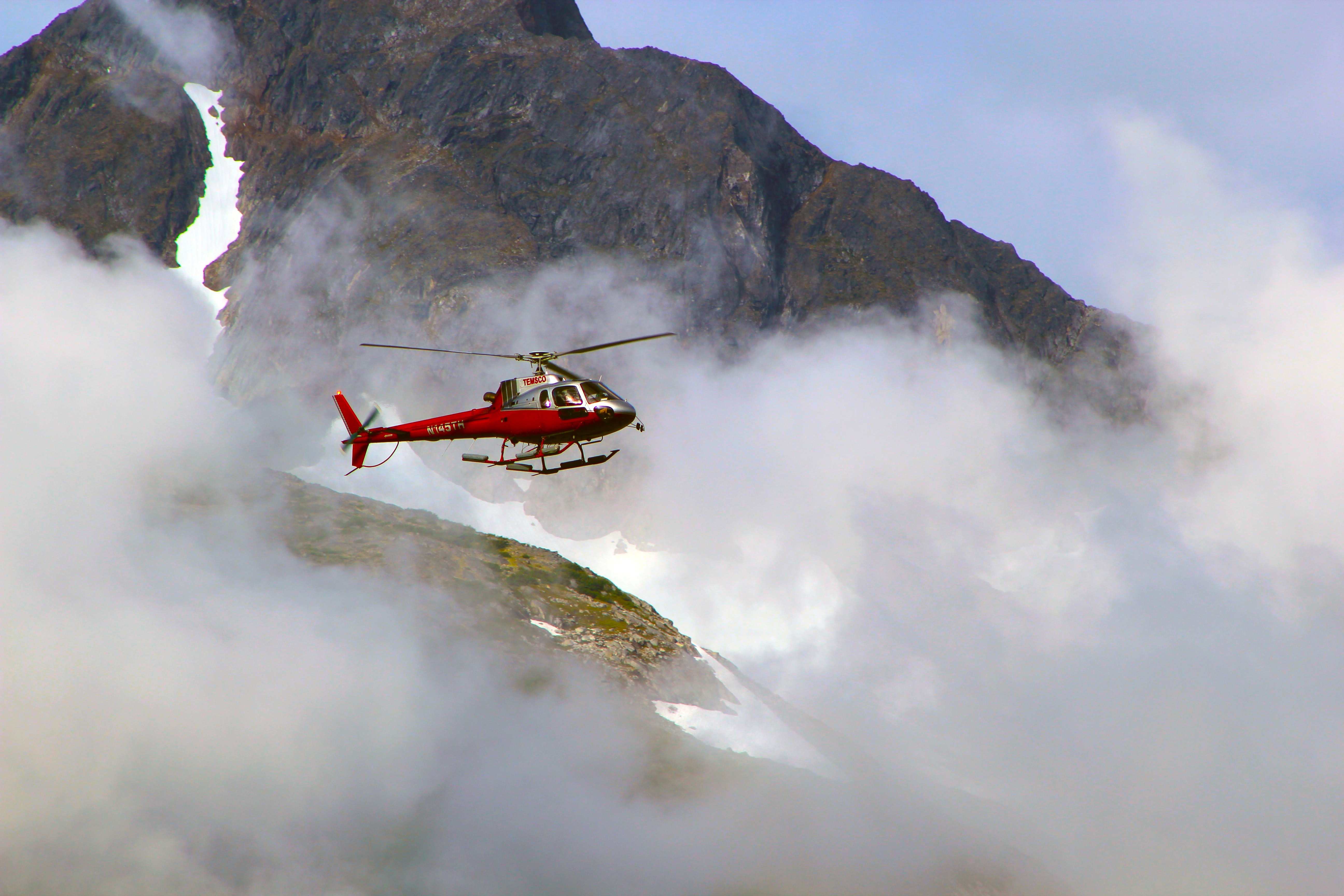 Red helicopter on top of foggy mountain photo