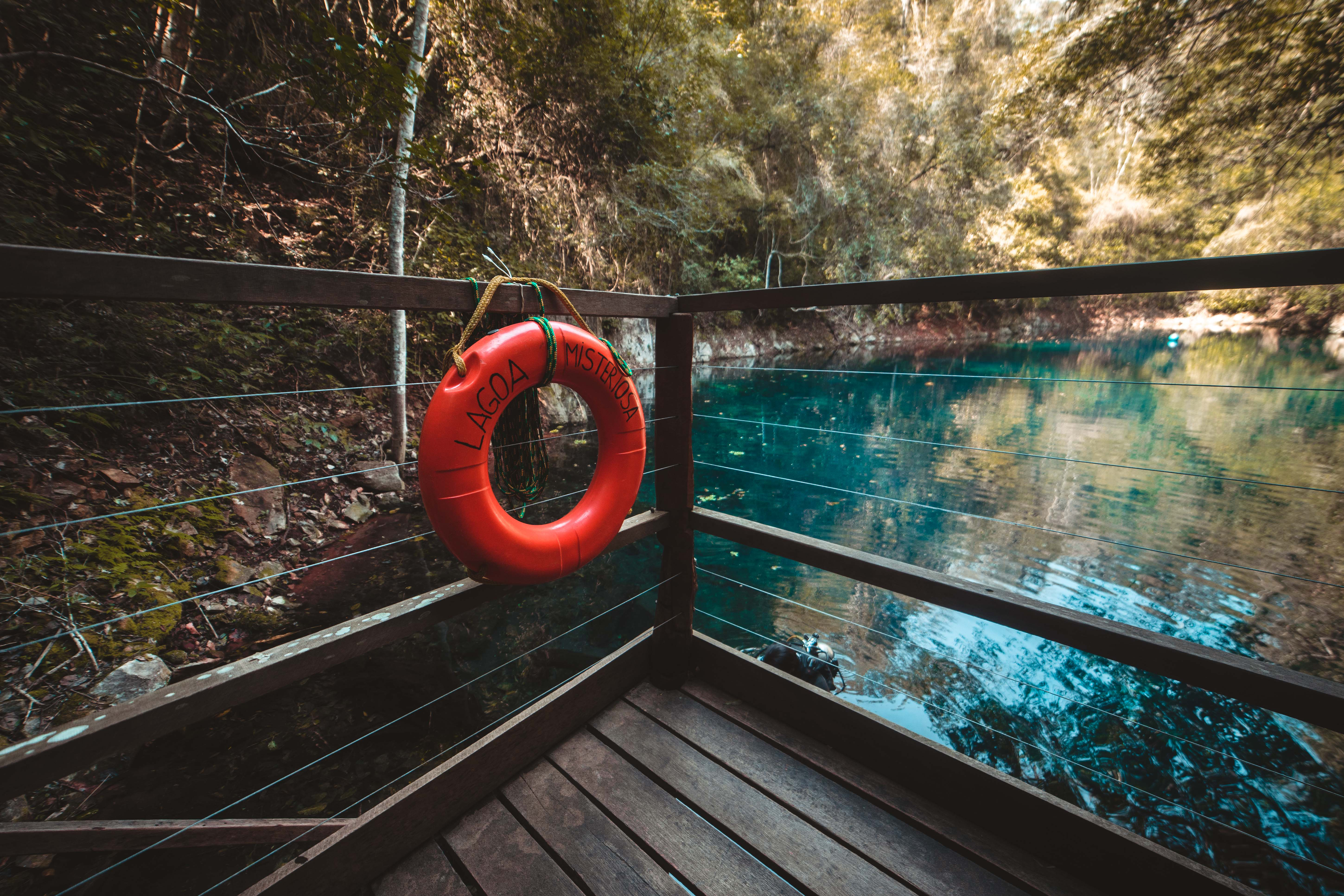 Red life buoy hanging on brown wooden balcony photo