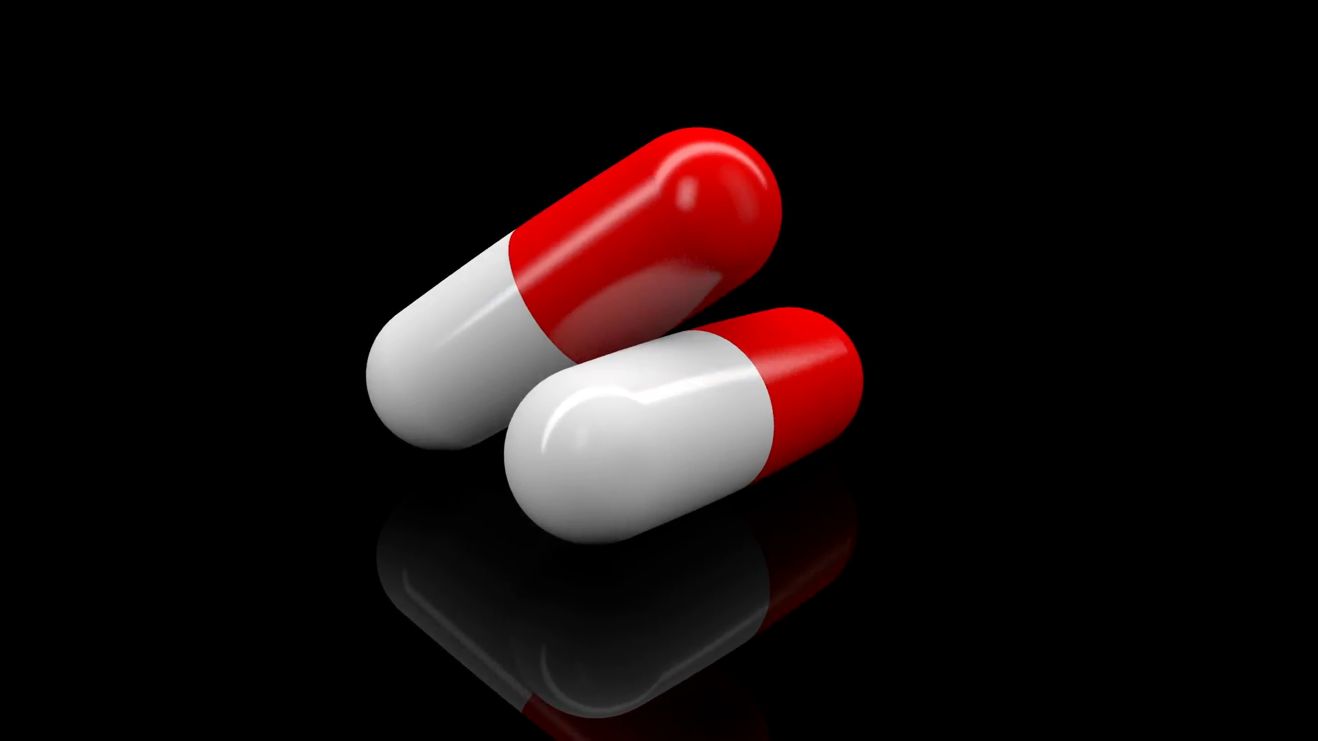 Two pills in white and red colors rotating on black background. 