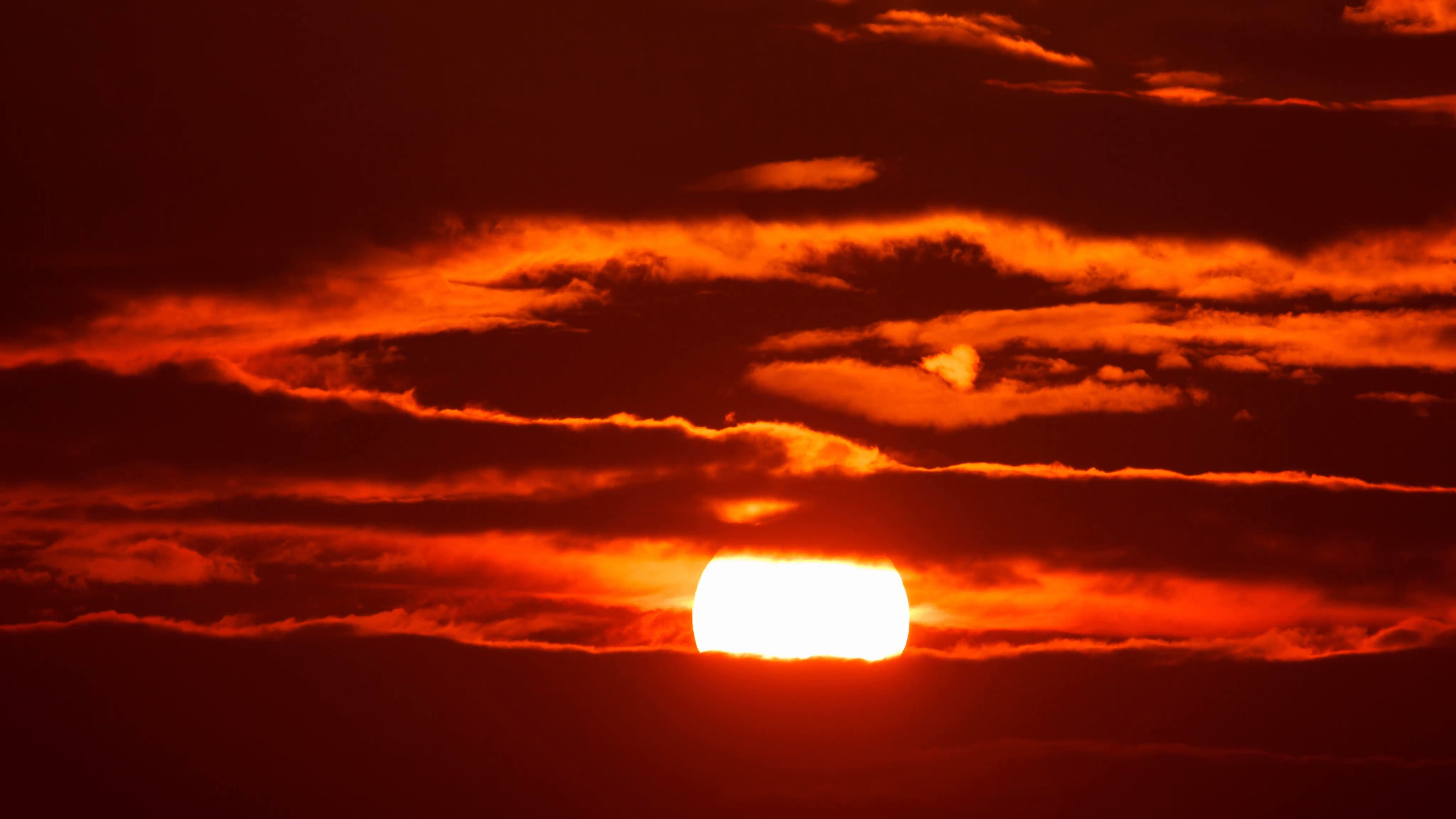 4K. Beautiful scenic sunset sun moving across red sky background ...