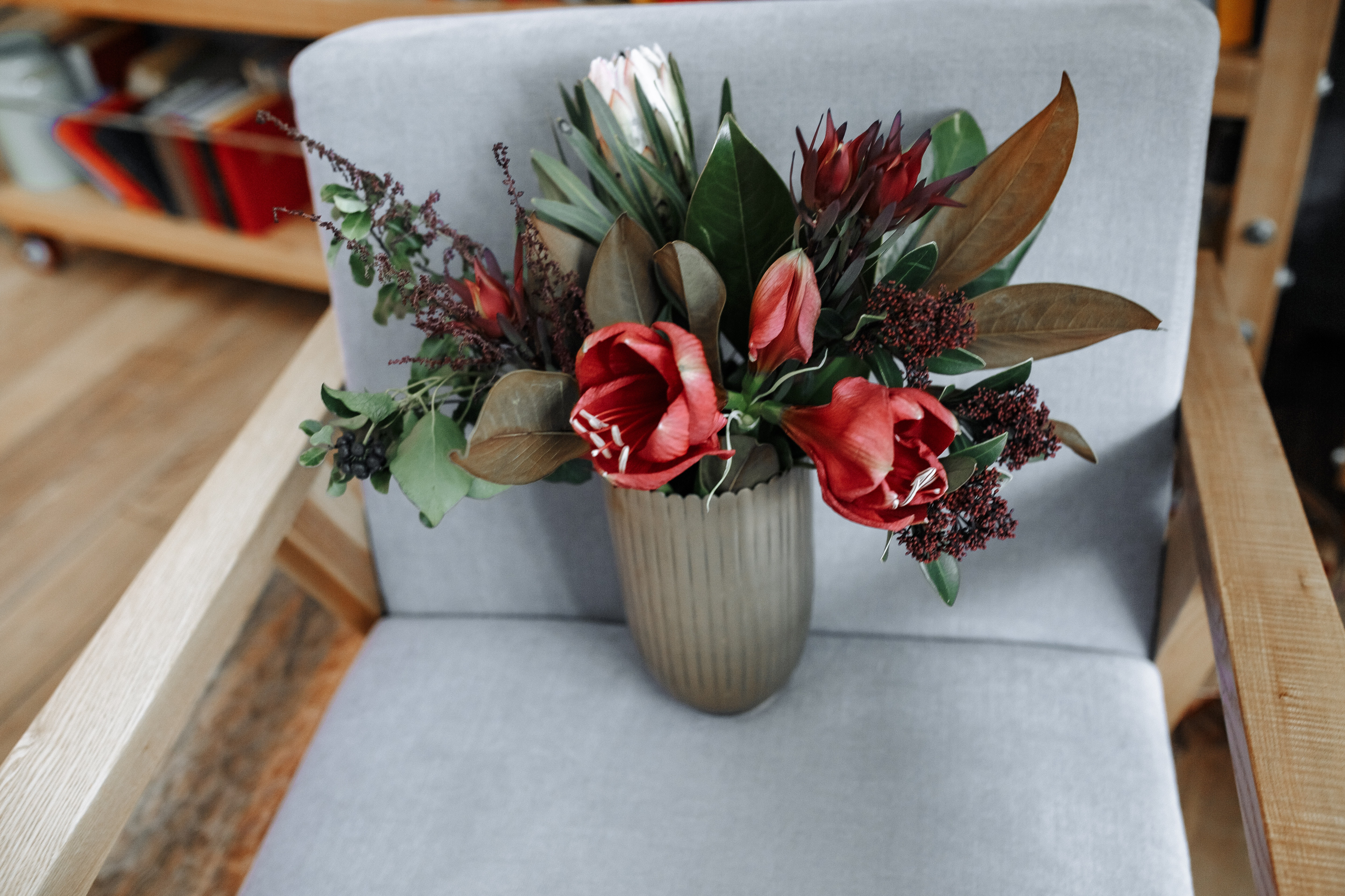 Red tulip flowers in vase on armchair photo