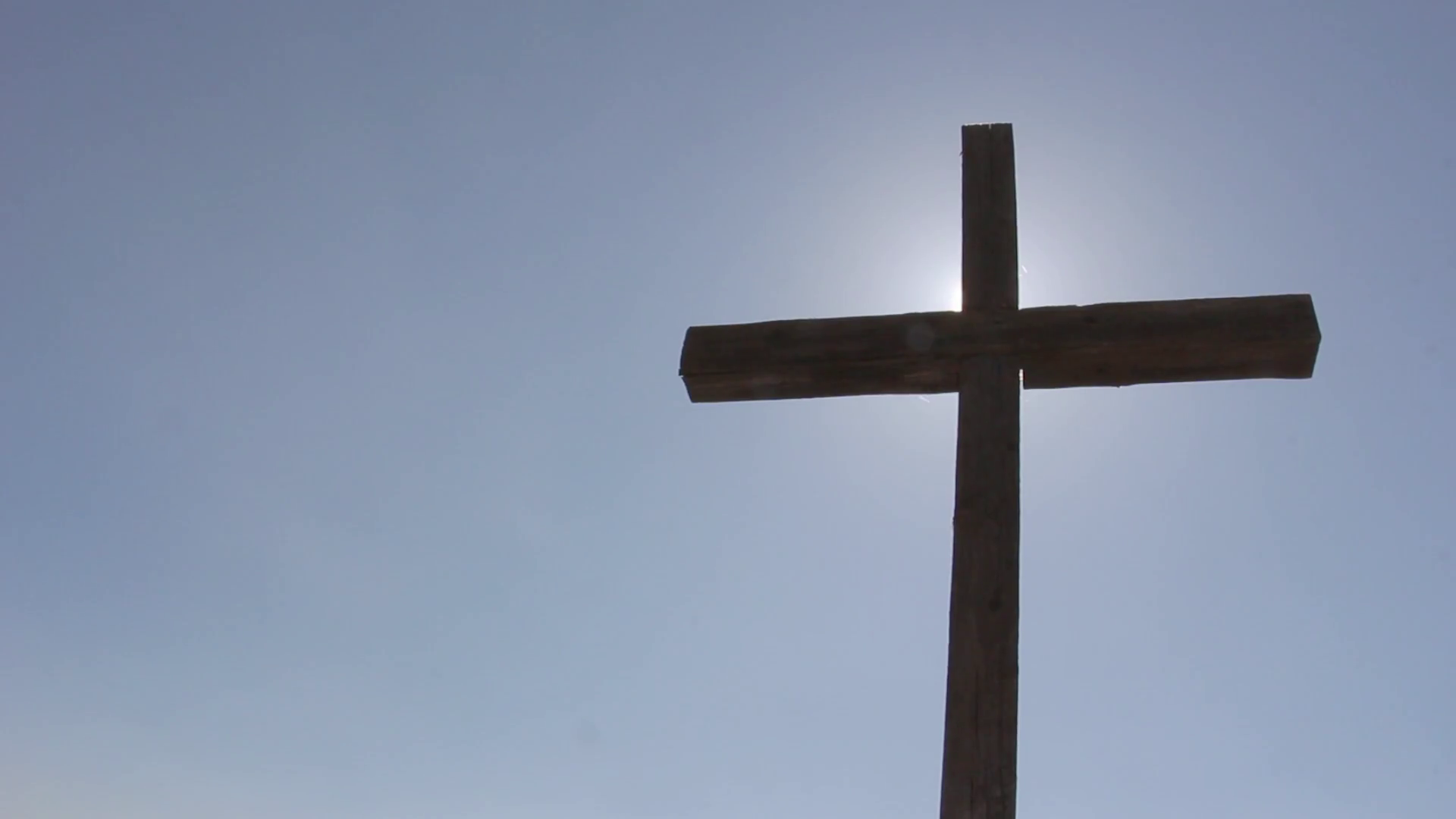 large wooden cross, against blue sky, sun glare, Faith in God ...