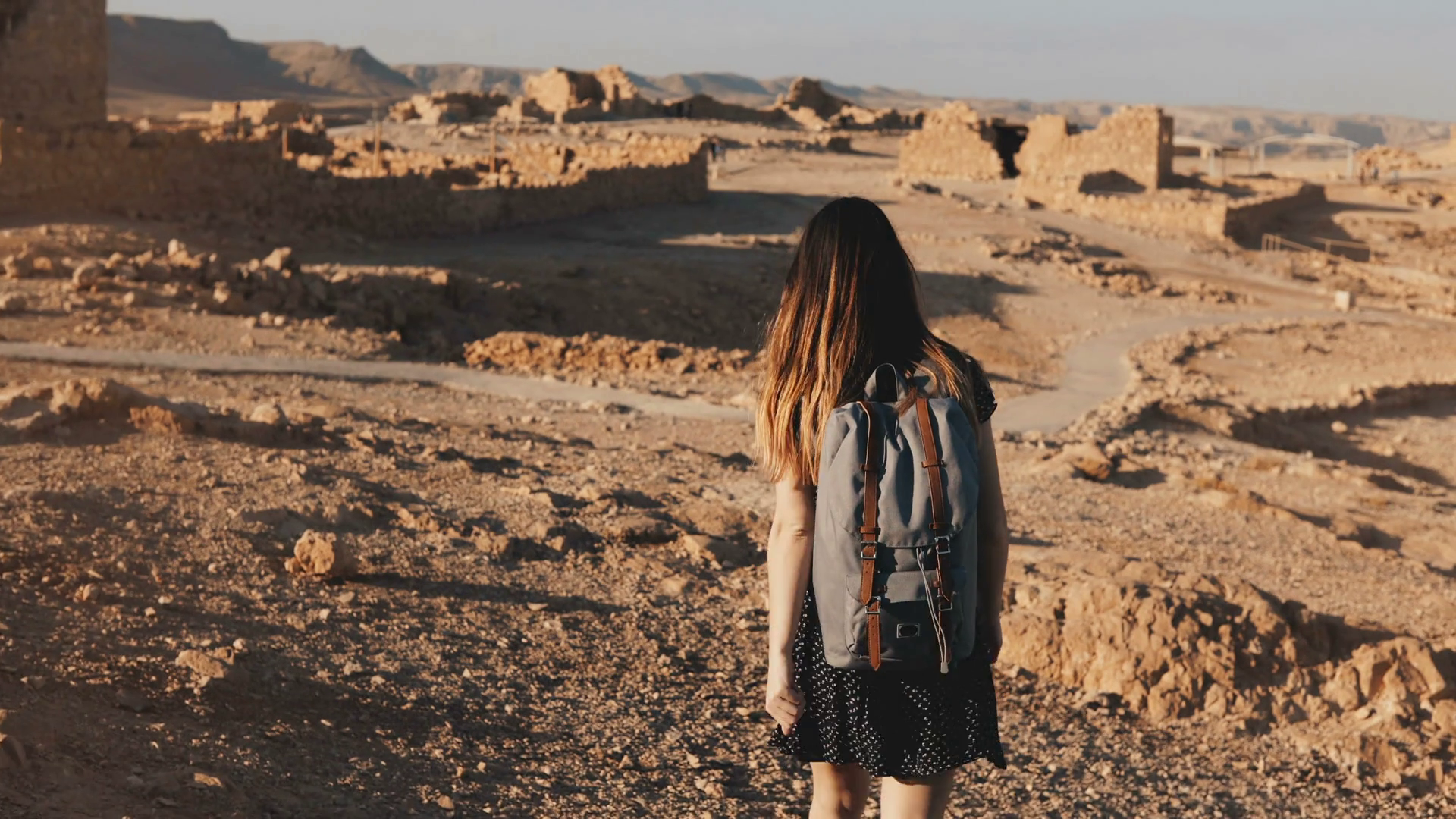 Woman with backpack explores ancient desert ruins. Beautiful ...