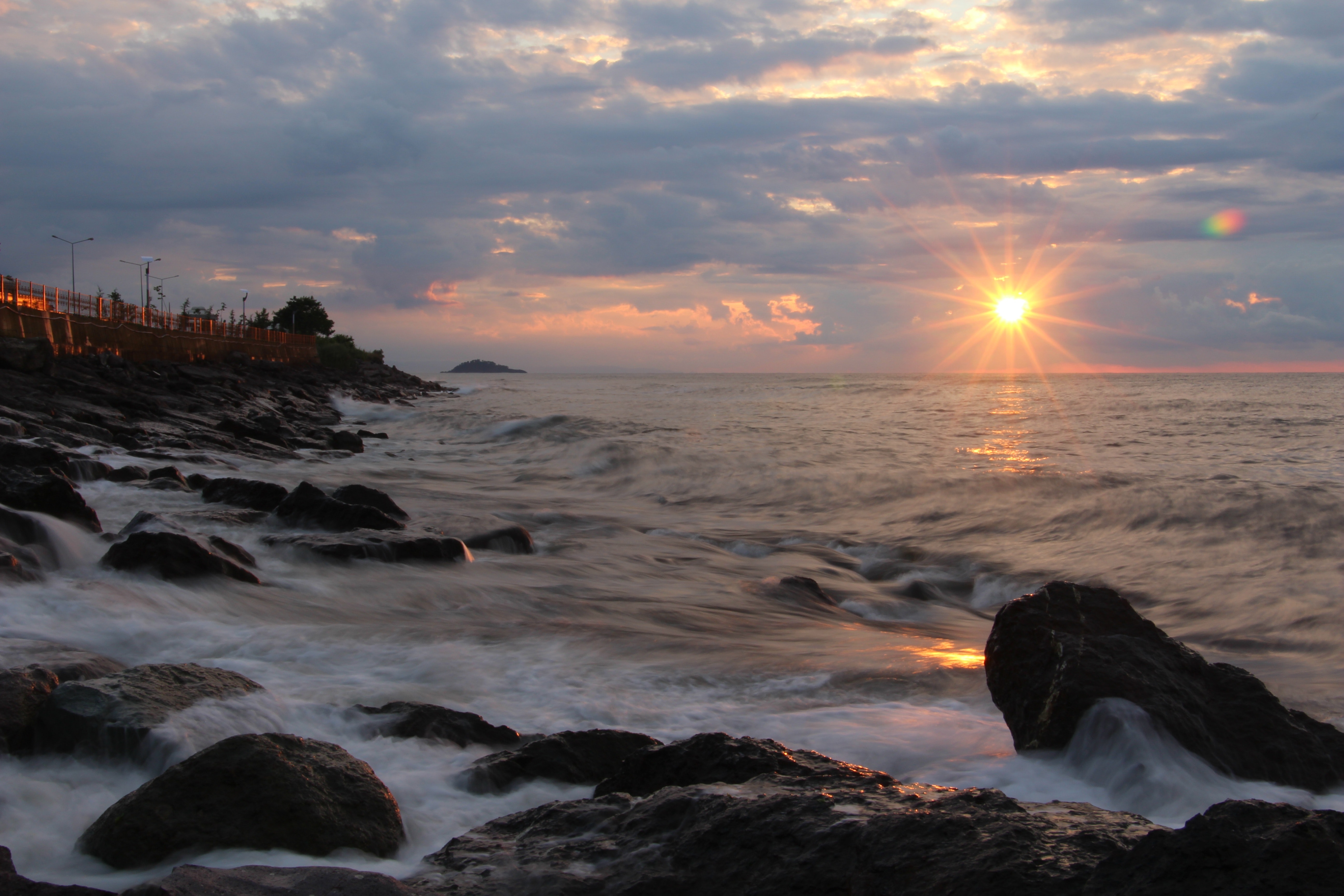Rocks on seashore during sunset photo