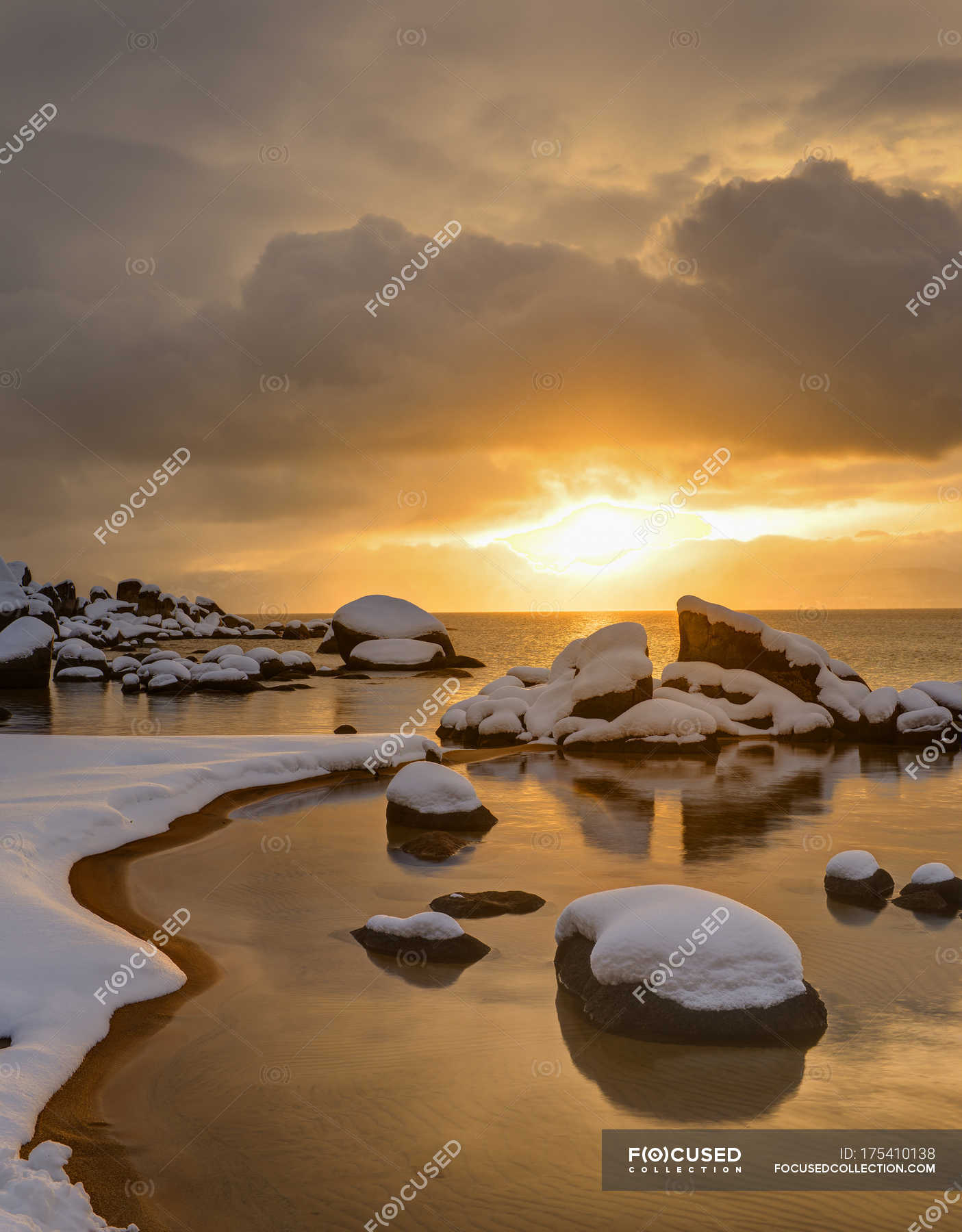 Sunset light above snowcapped rocky shore of Lake Tahoe — Stock ...