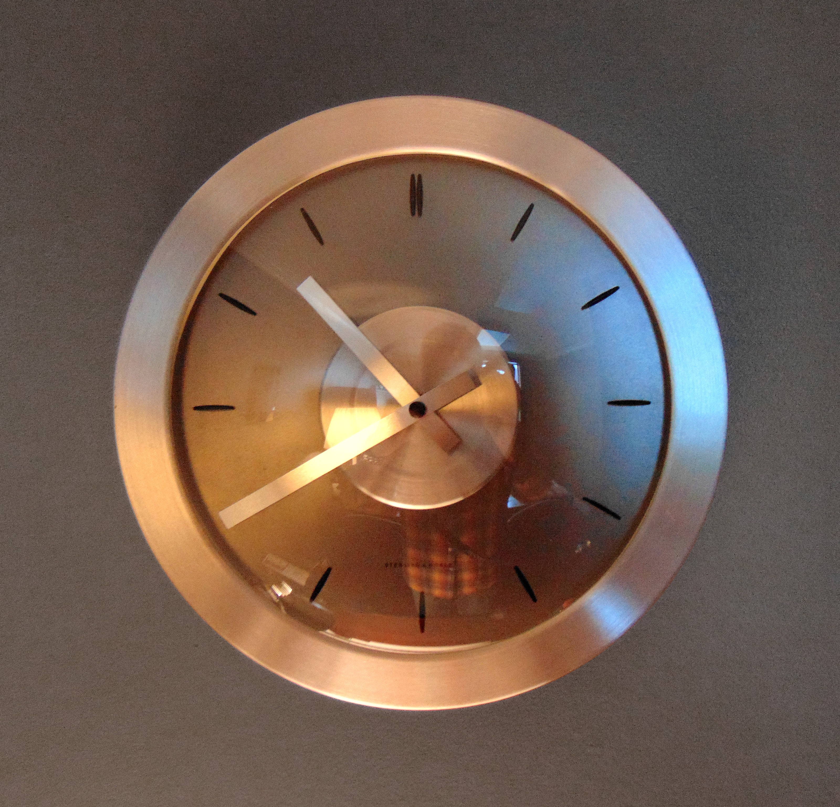 Round bronze analog wall clock photo