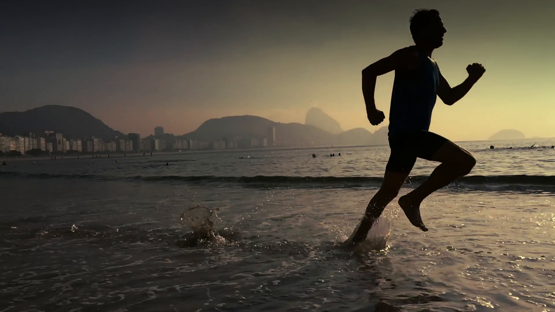 Athletic man running in slow motion through the waves on Copacabana ...