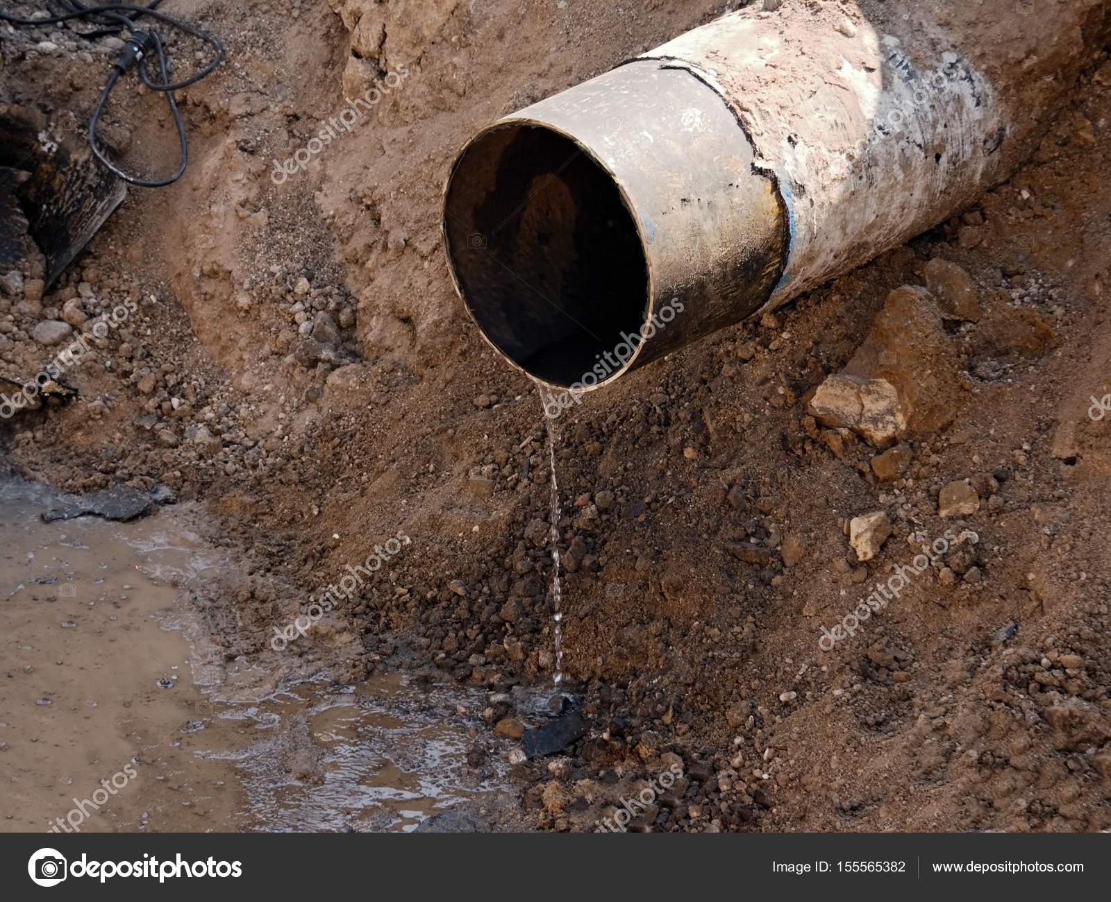 Rusty Old Iron Pipe With Clear Water Flowing From It. Waste water ...