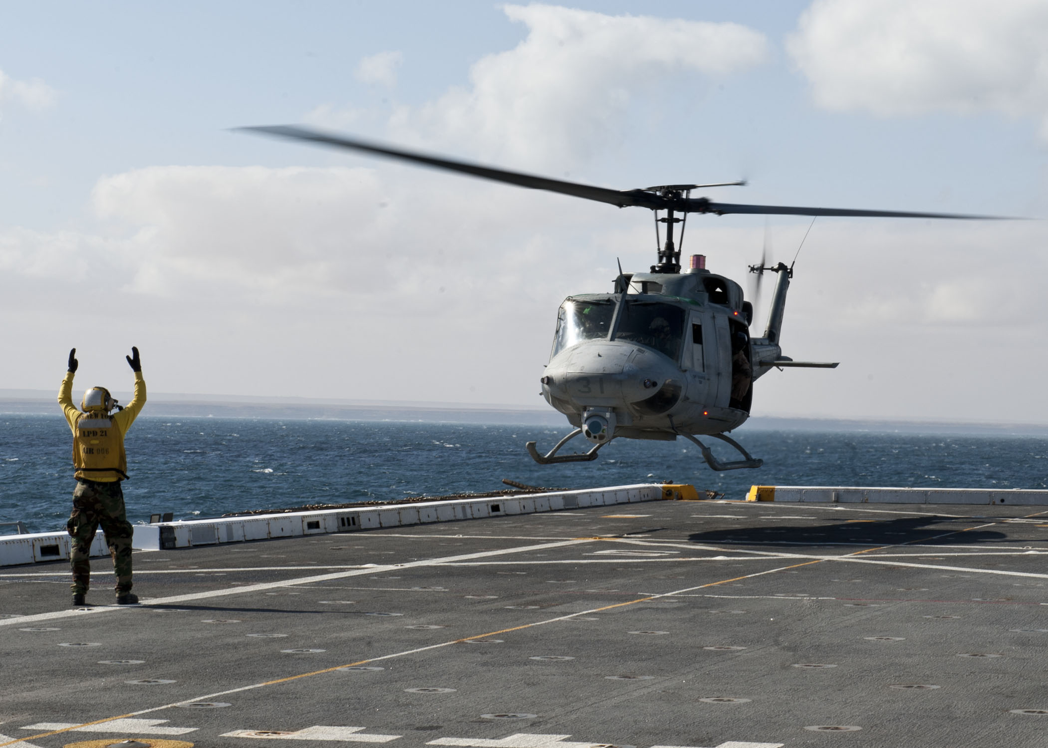 File:A U.S. Sailor directs a UH-1N Huey helicopter during flight ...