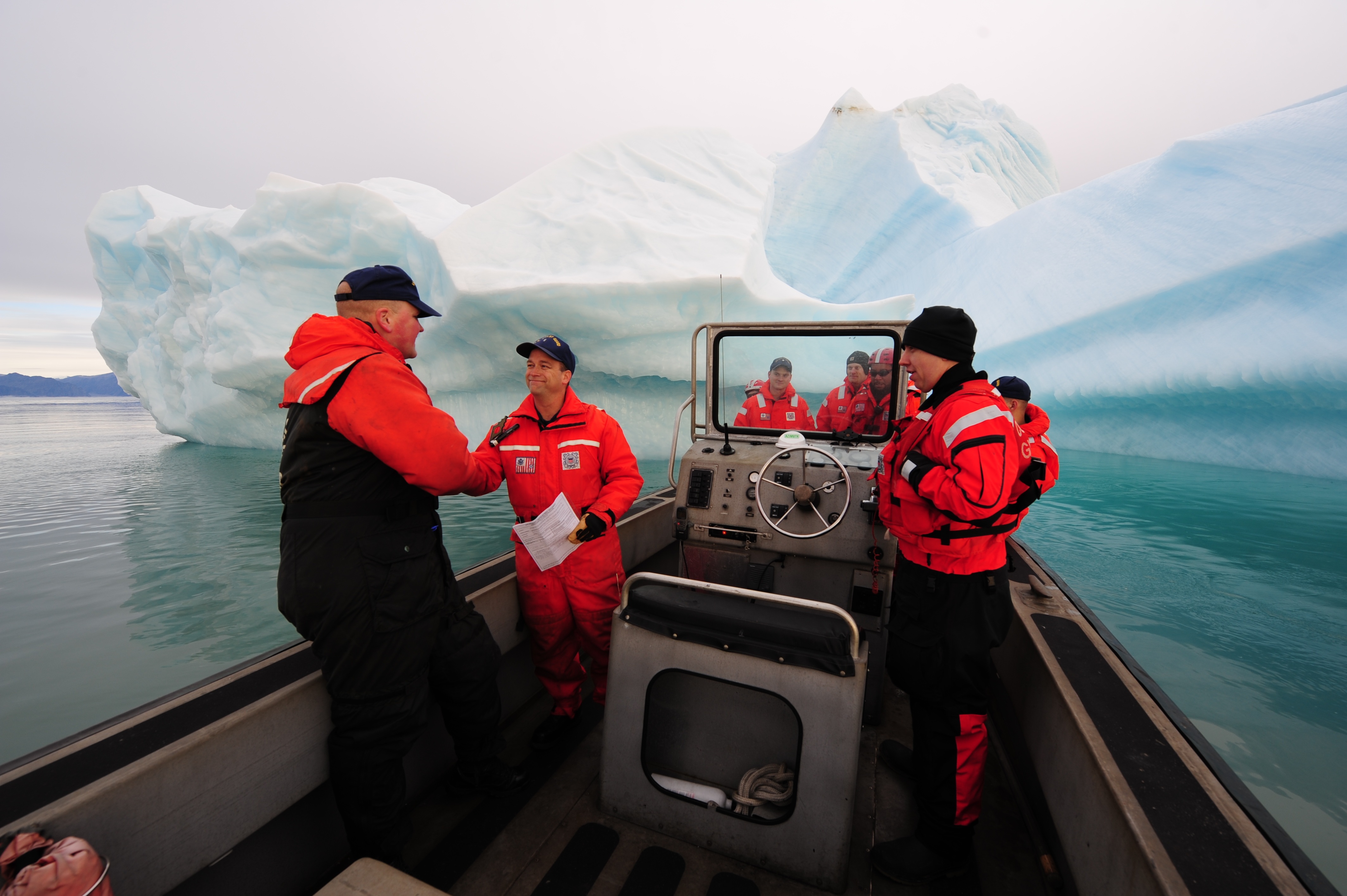 Sailors near a giant iceberg photo