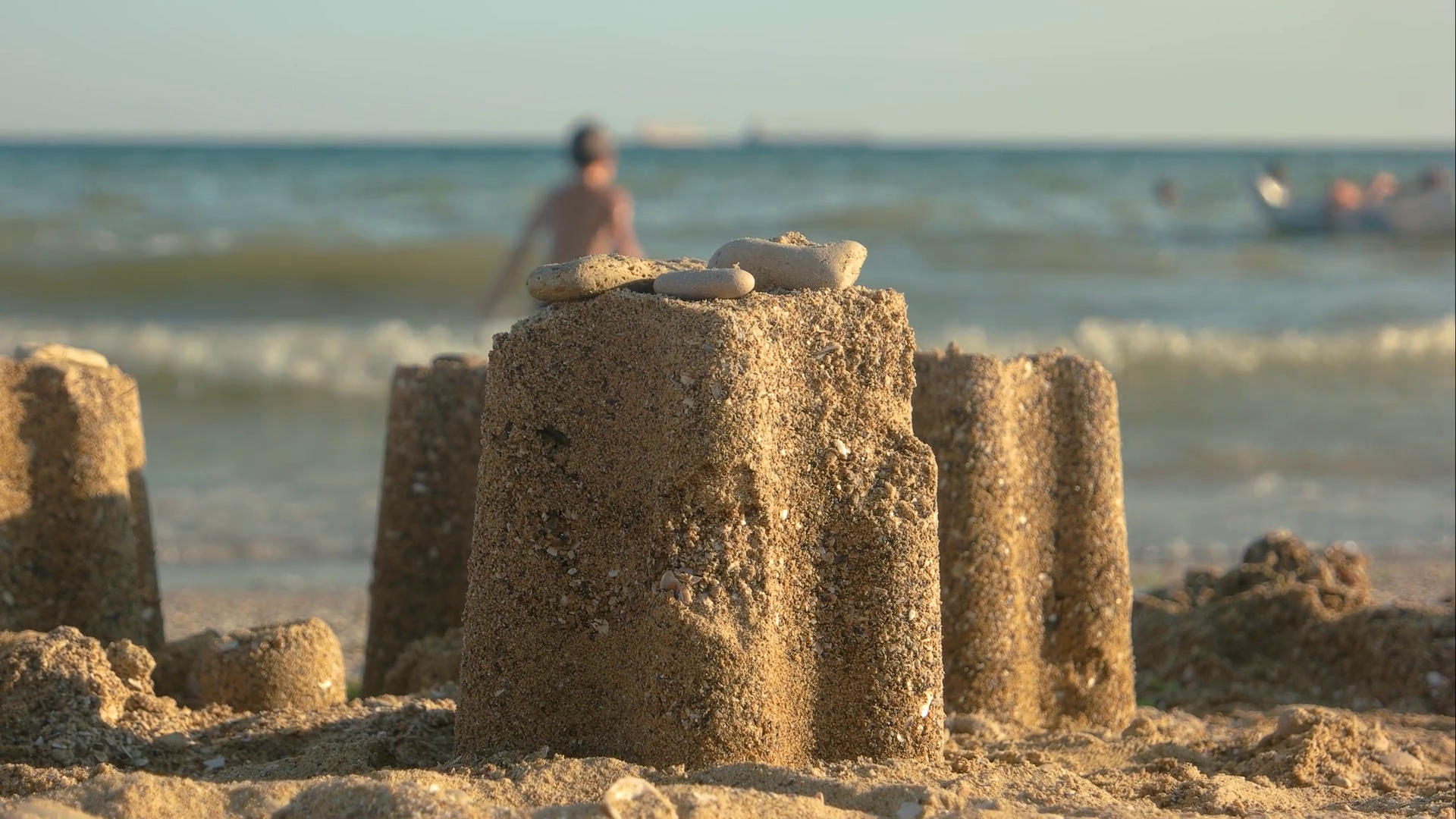 Close up of sand tower. Blurred beach and people. Stock Video ...