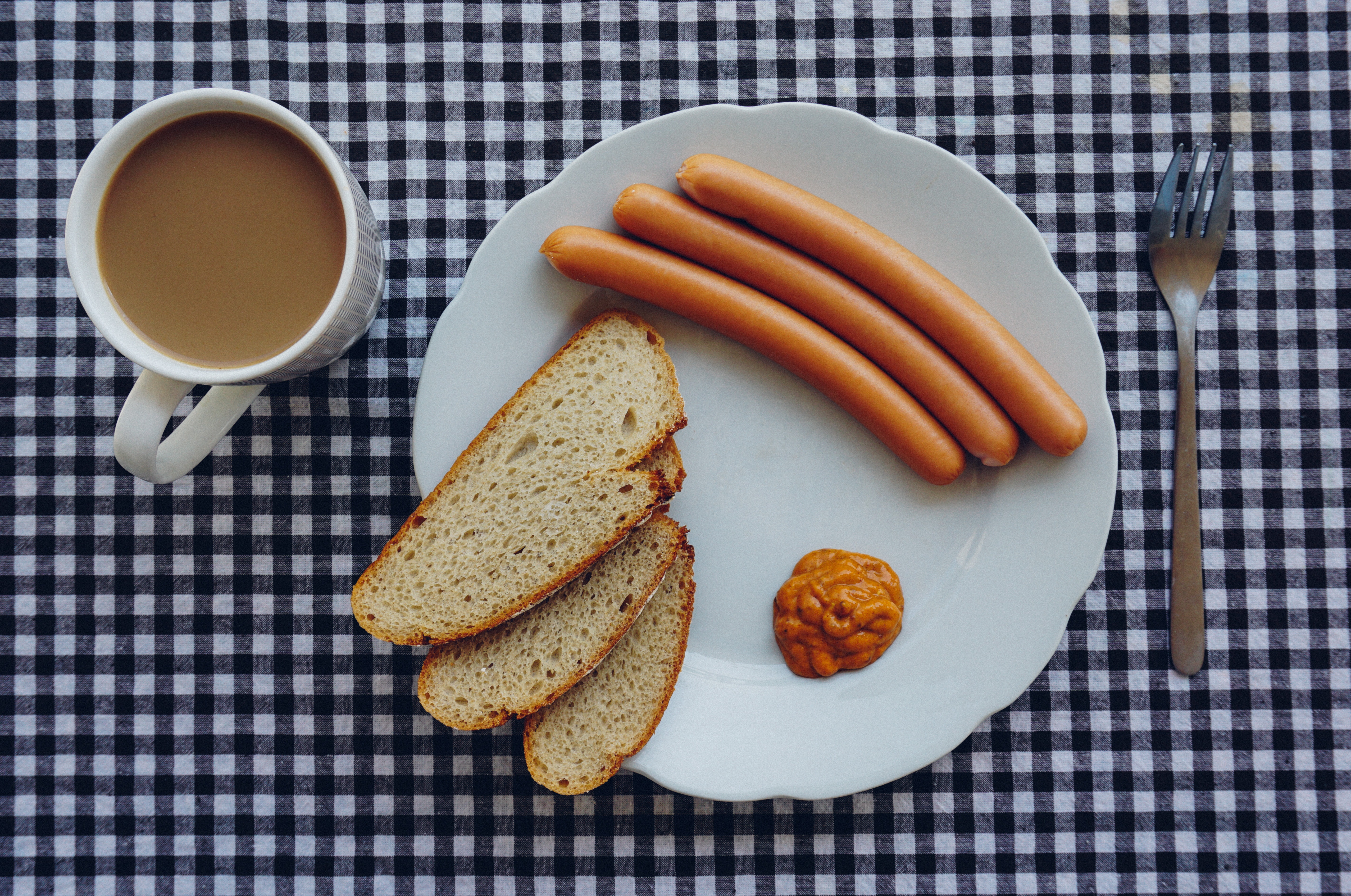 Sausages, bread and coffee on table photo