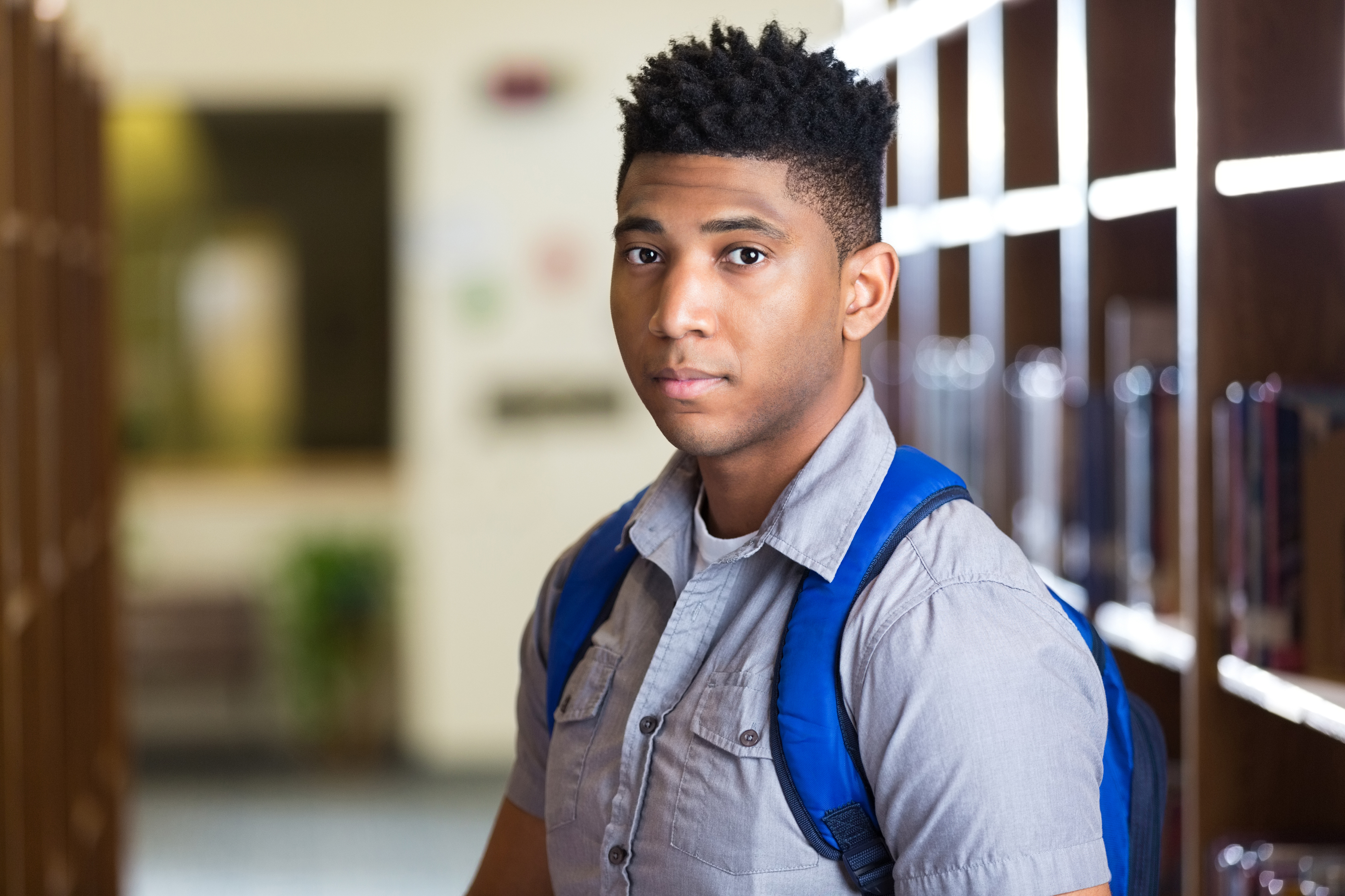 Serious African American high school boy in library - College ...