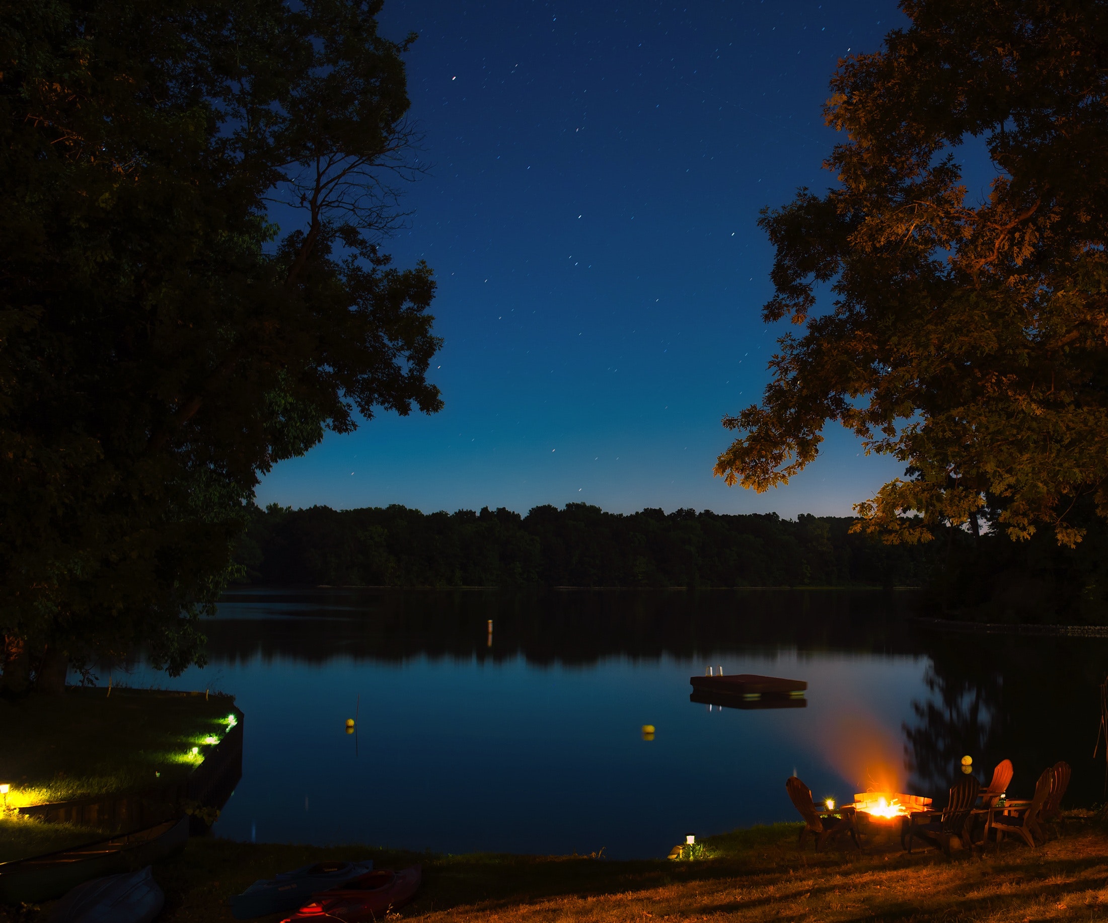 Sea body of water near trees during nighttime photo