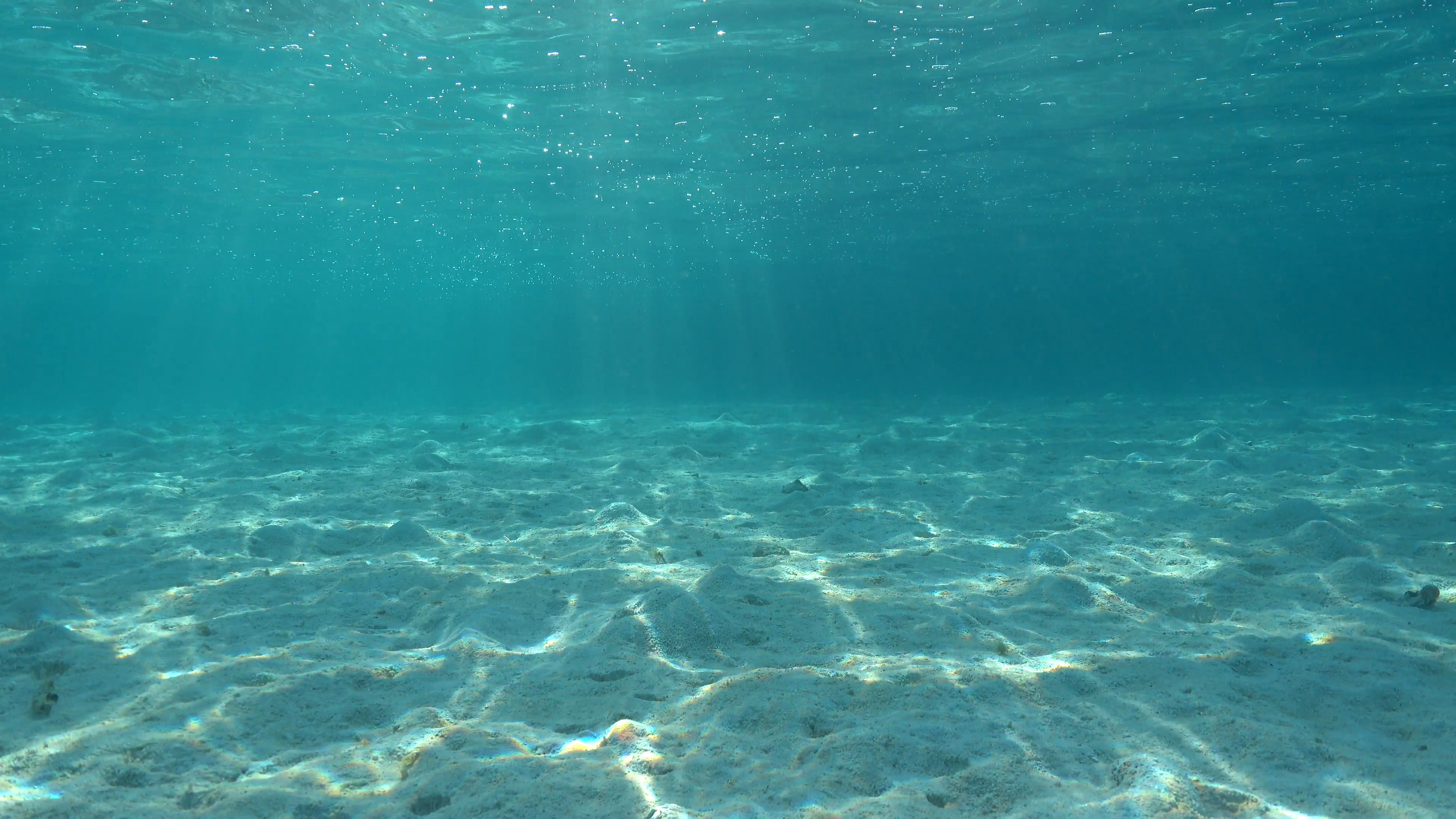 Underwater shallow sandy ocean floor with sunlight through water ...