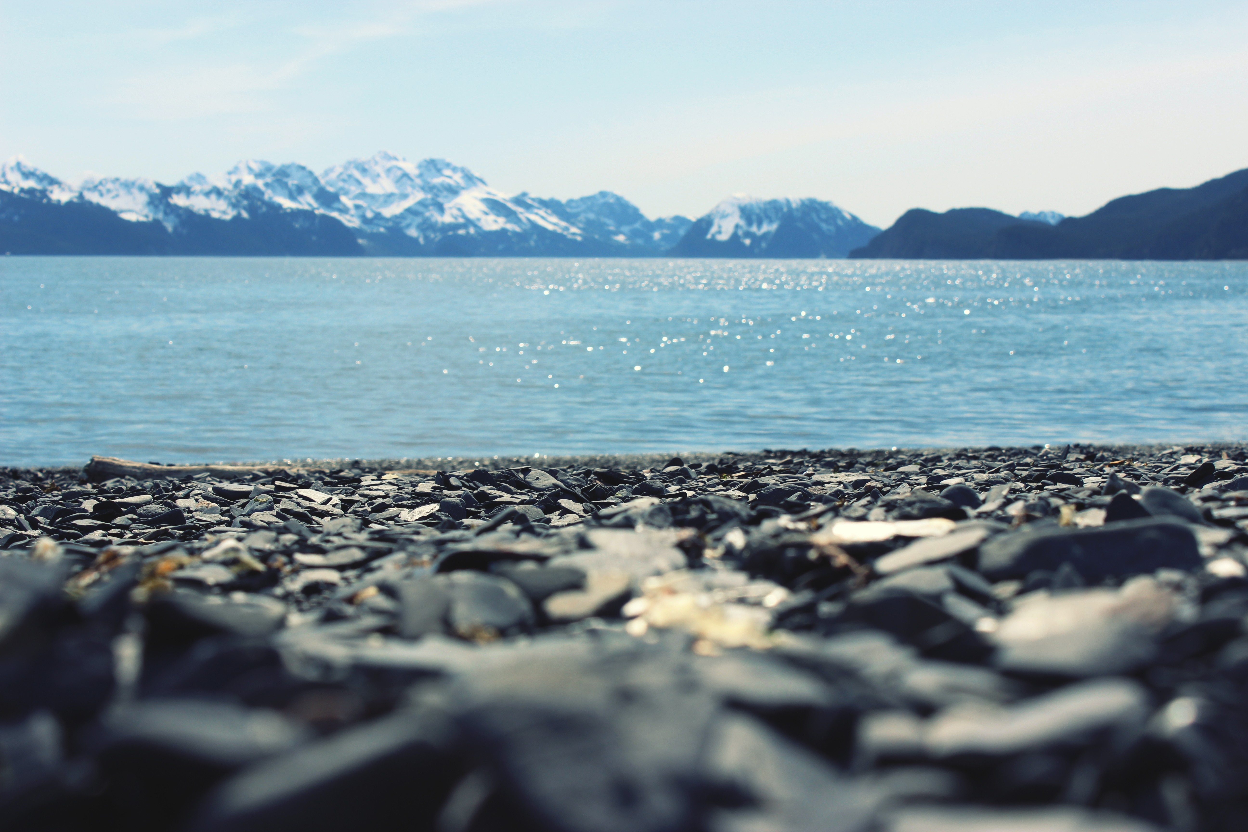 close photo of seashore near body of water and mountains free image ...