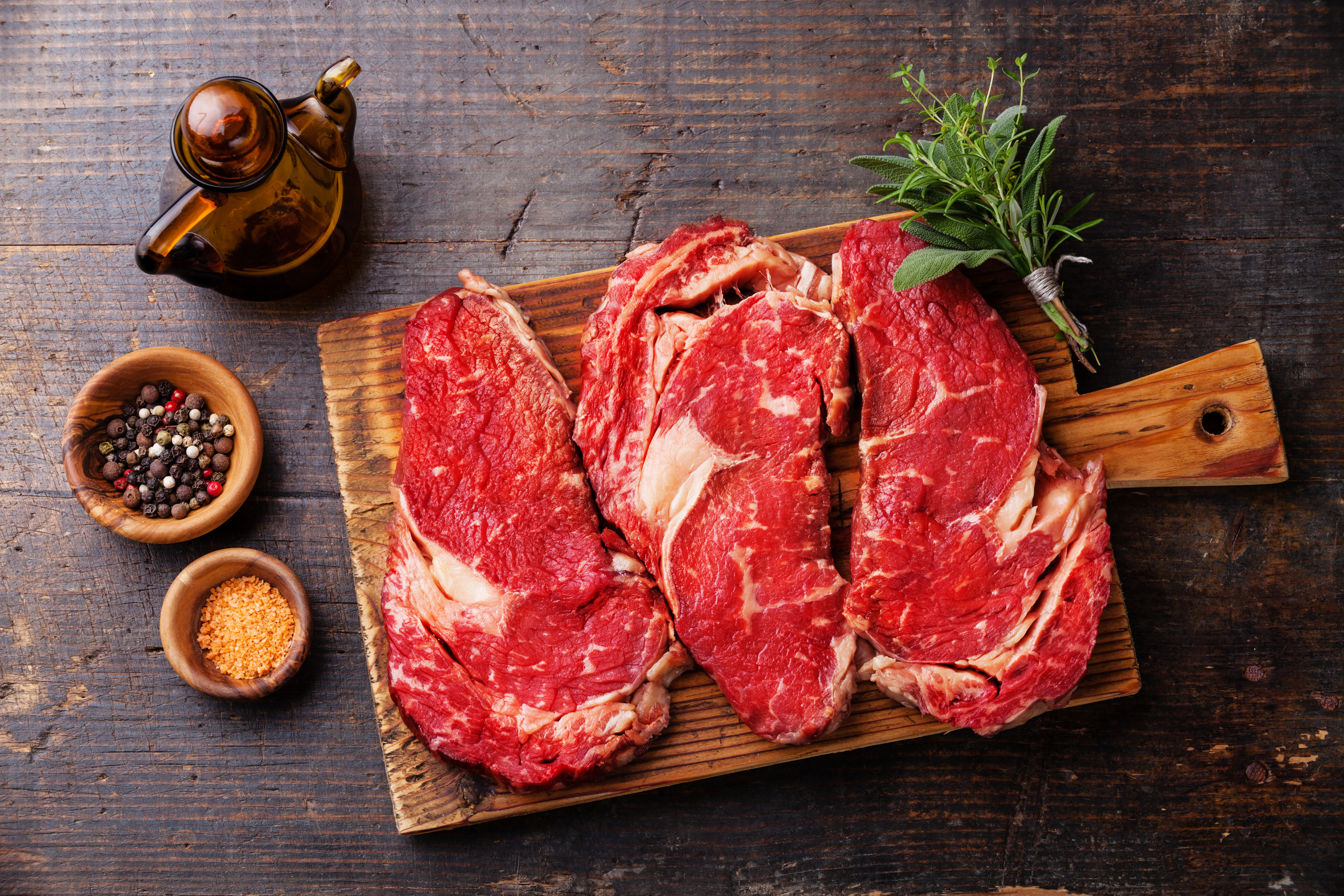 Raw fresh meat Ribeye steak entrecote and seasoning on dark wood |