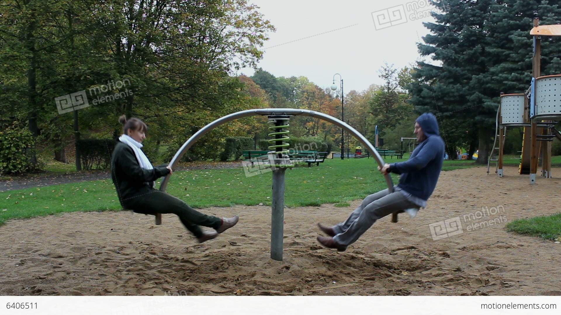 Two Adults Have Fun On The Seesaw Springer Stock video footage | 6406511