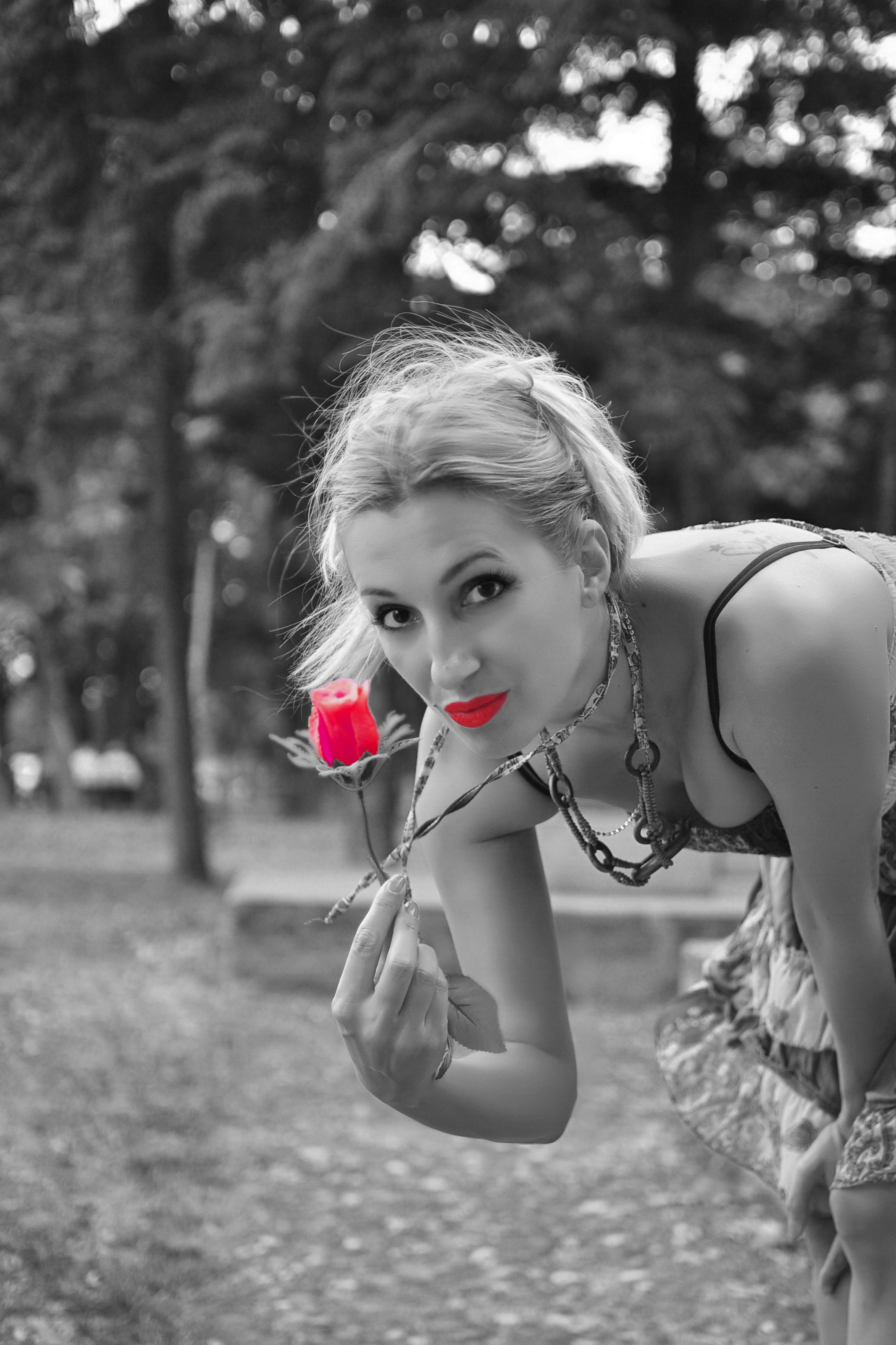 Selective color photo of woman holding rose