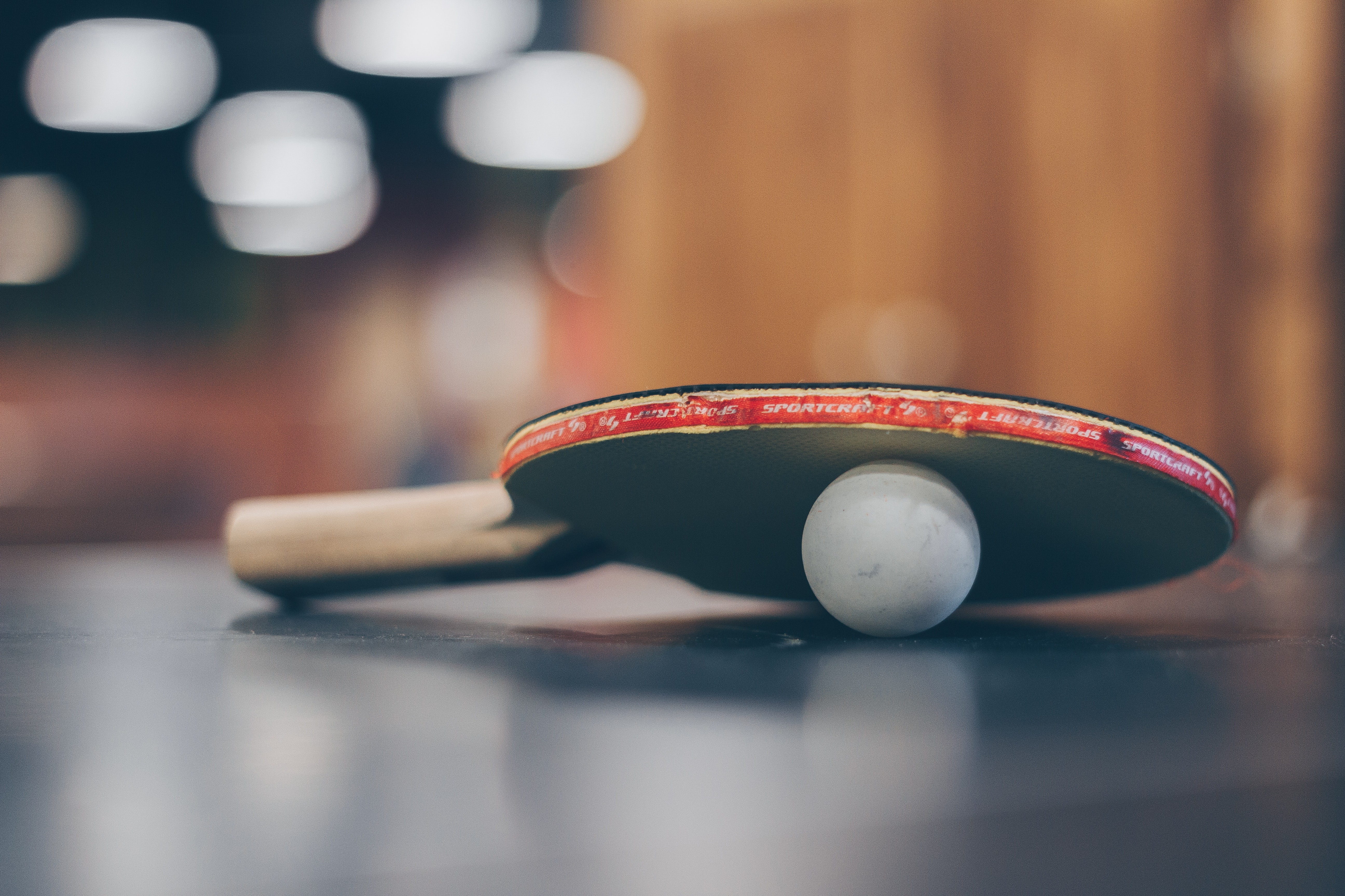 Selective focus photo of table tennis ball and ping-pong racket