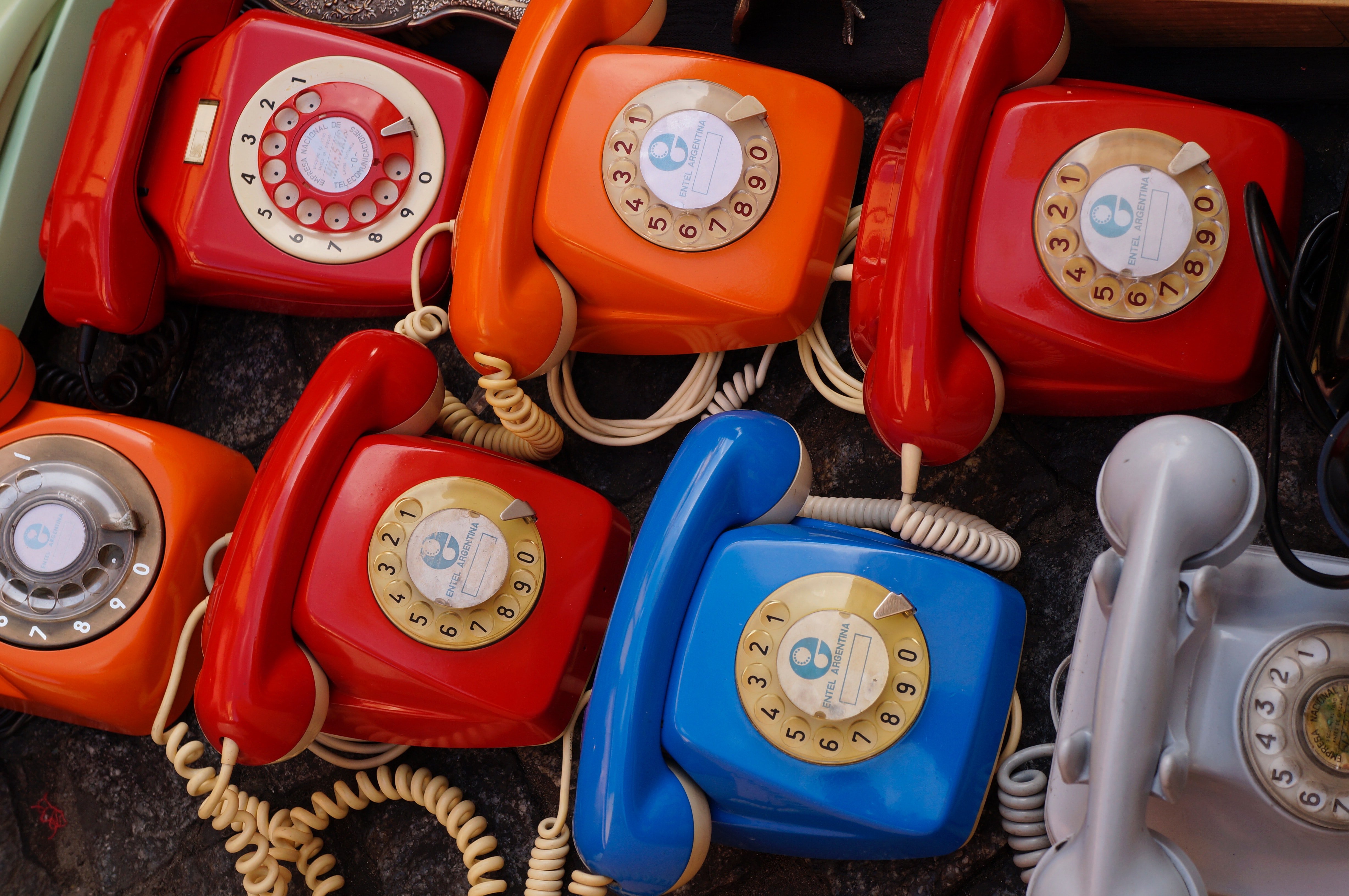 Seven assorted colored rotary telephones photo