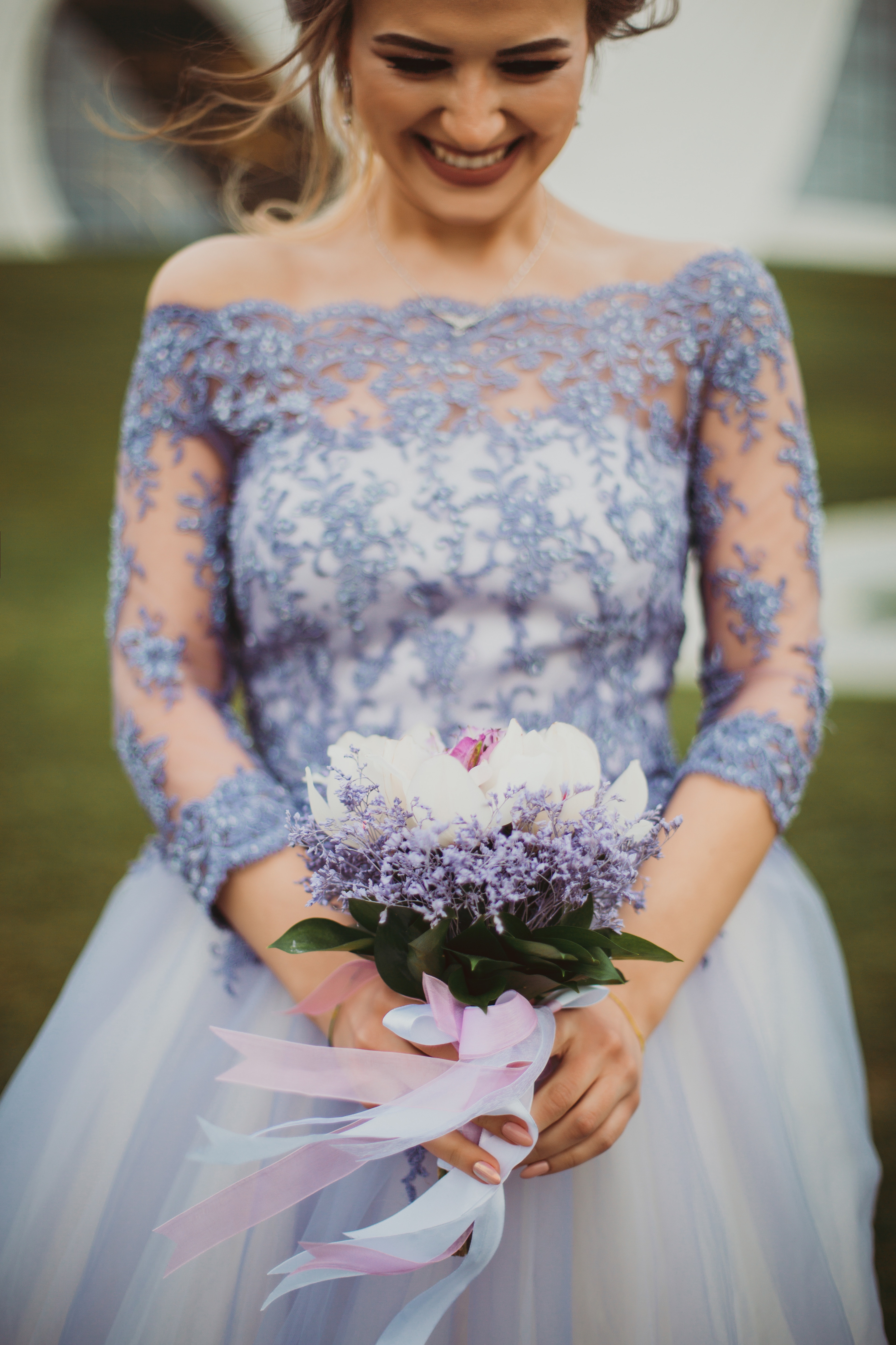 Shallow focus on purple floral off-shoulder long-sleeved lace wedding gown photo