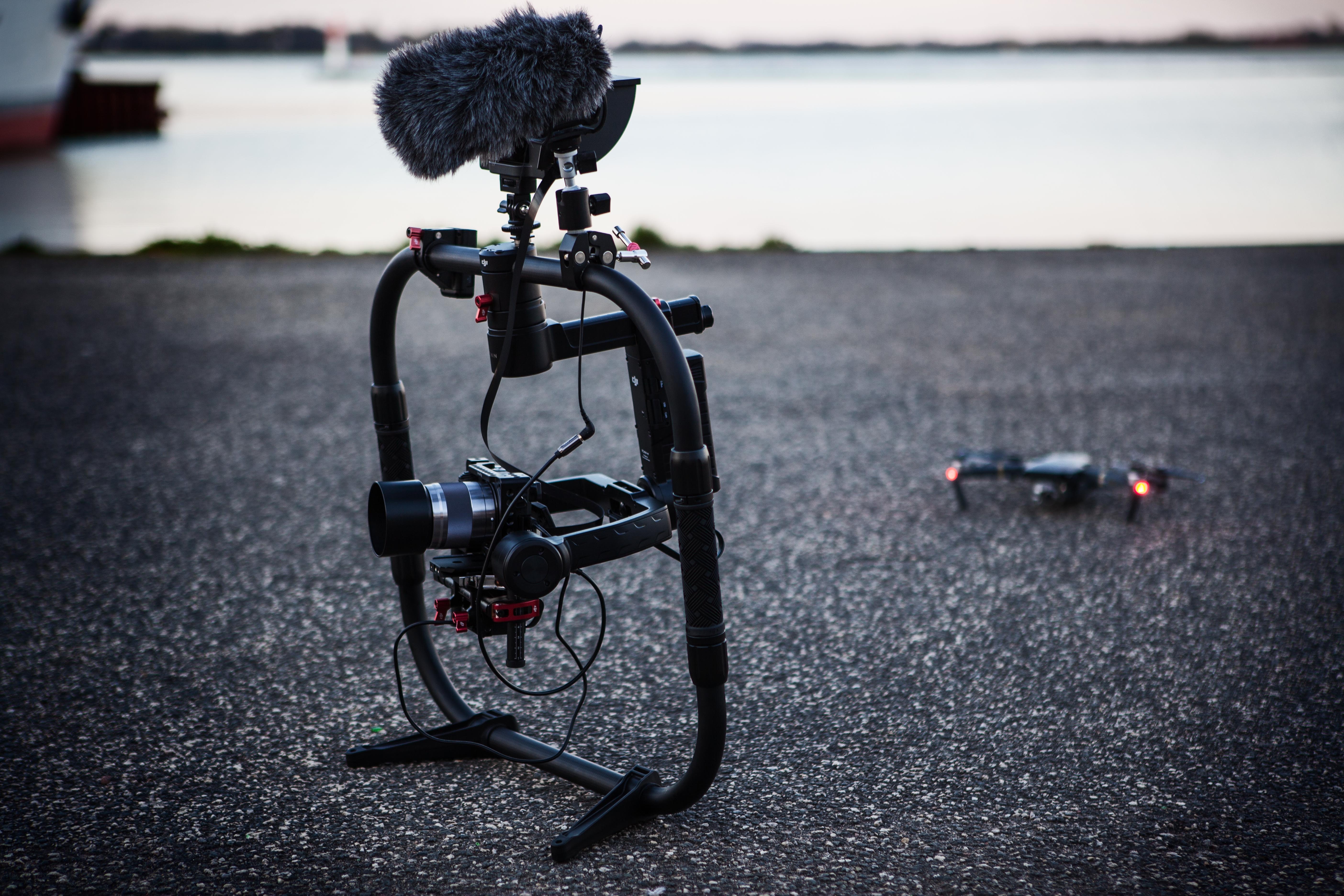 Shallow focus photography of black quadcopter near body of water