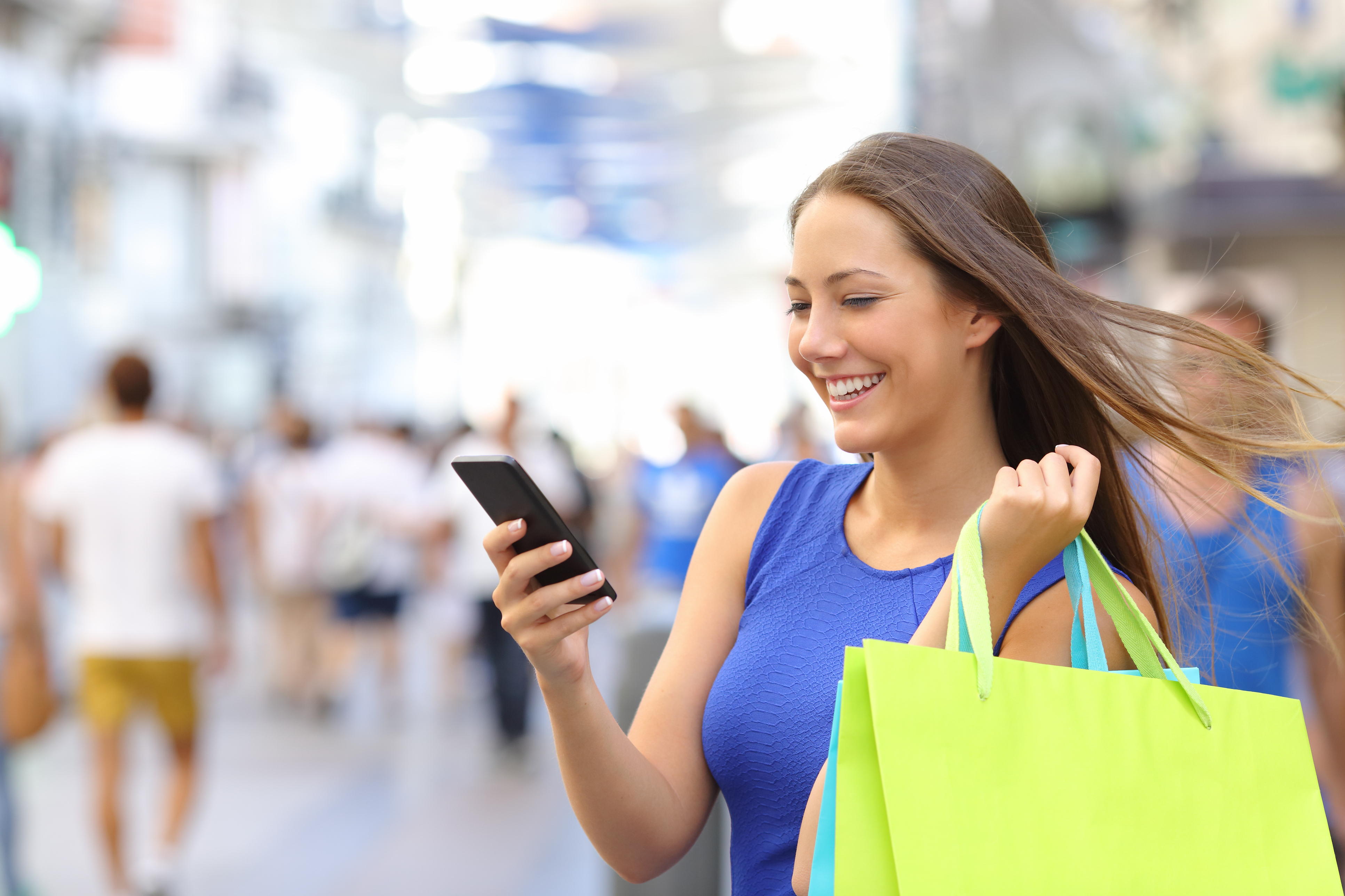 Shopper shopping with smartphone in the street - Global Biz Circle
