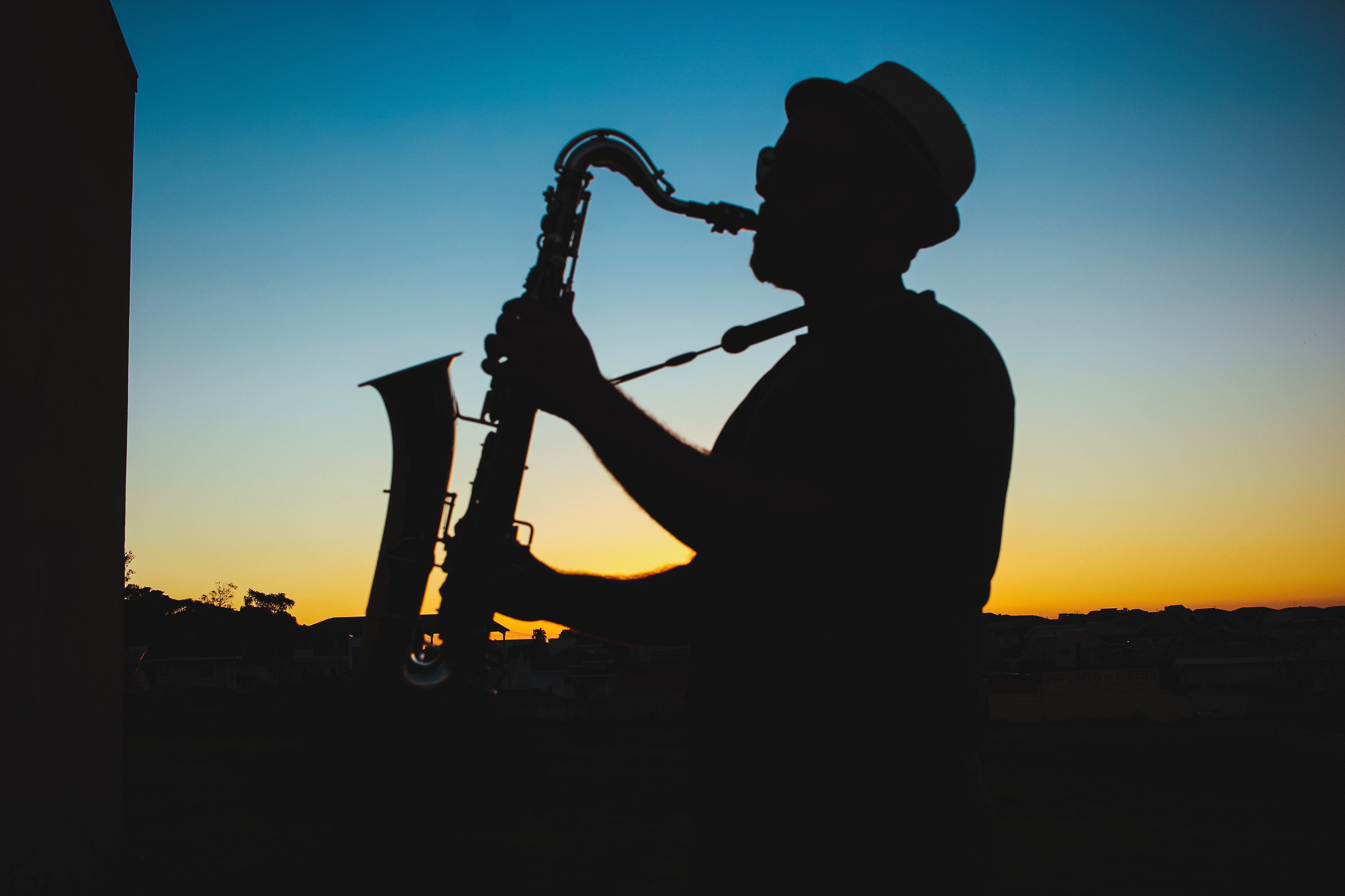 Silhouette of a man playing saxophone during sunset photo