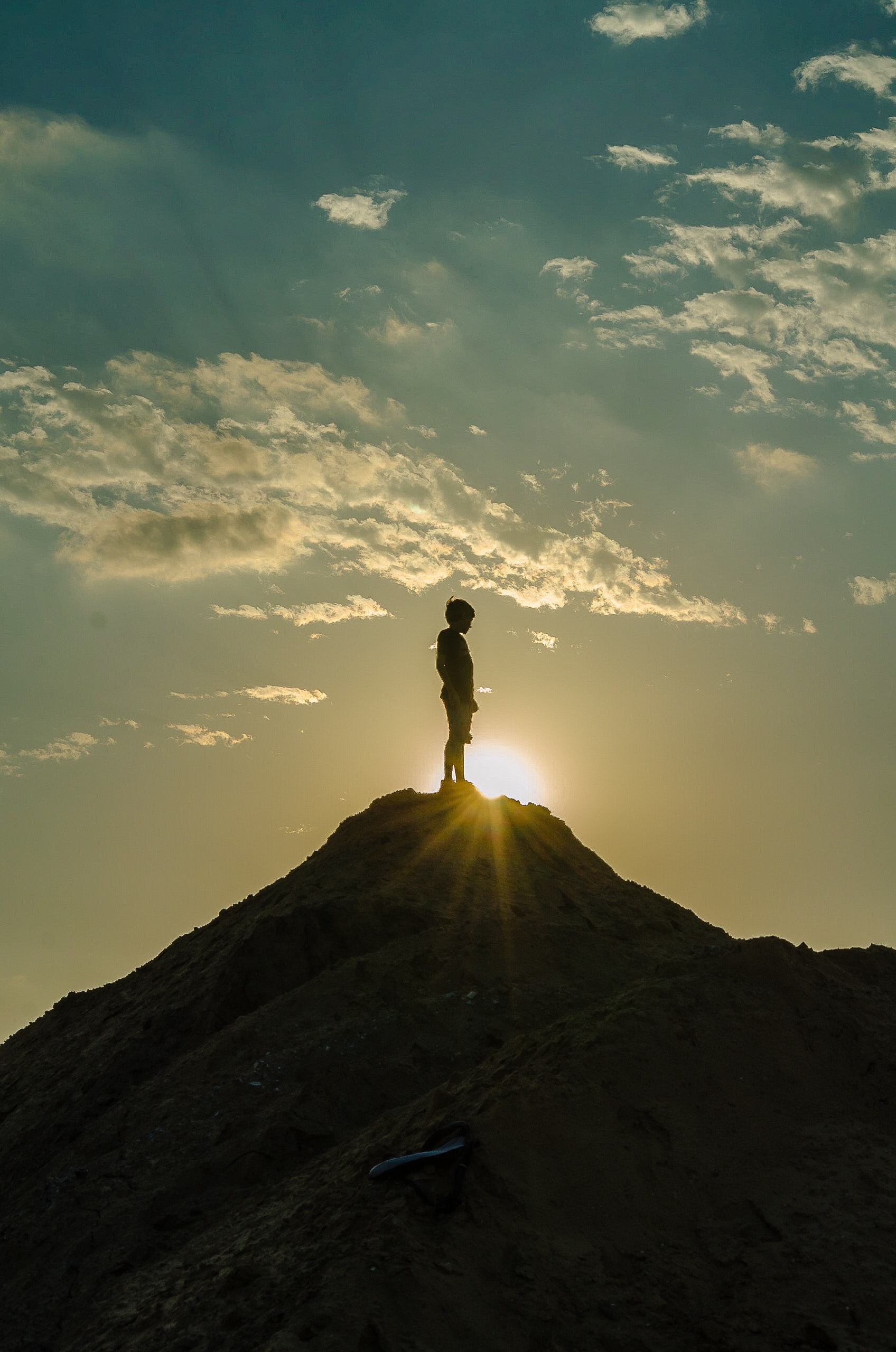 Silhouette of a man standing on a mountain photo