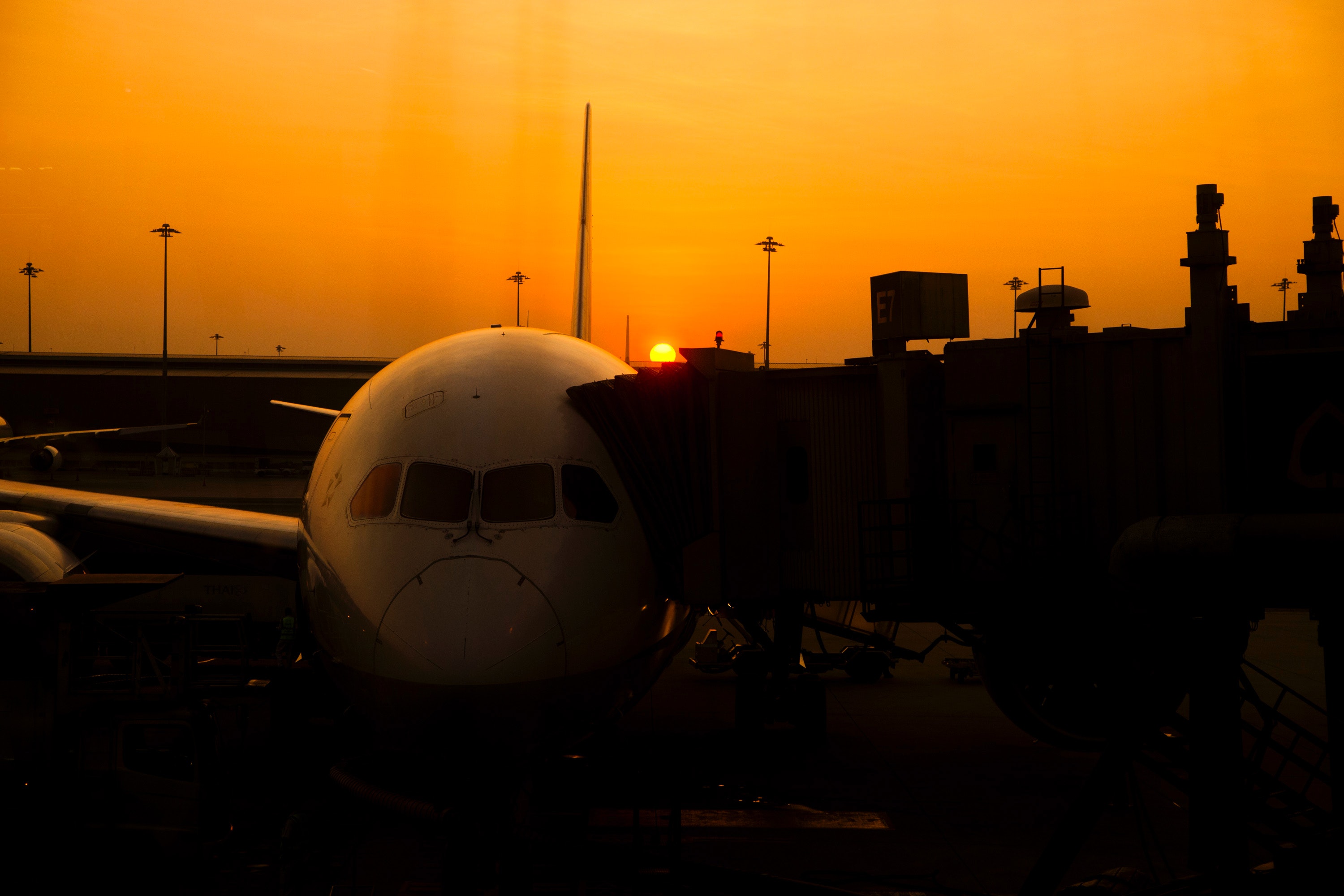 Silhouette of airplane on airport during sunset photo