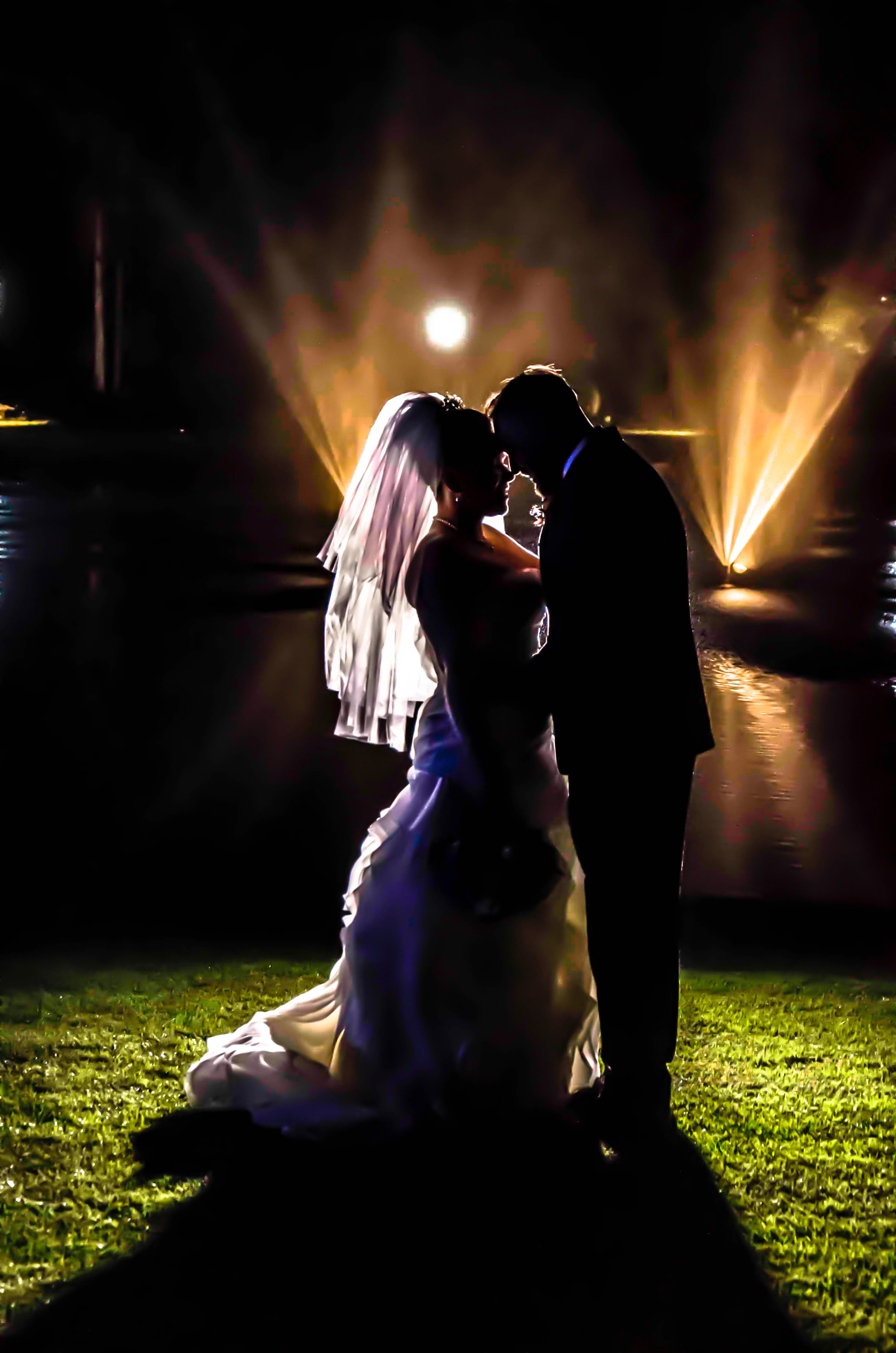 Silhouette of bride and groom on grass field during night times photo