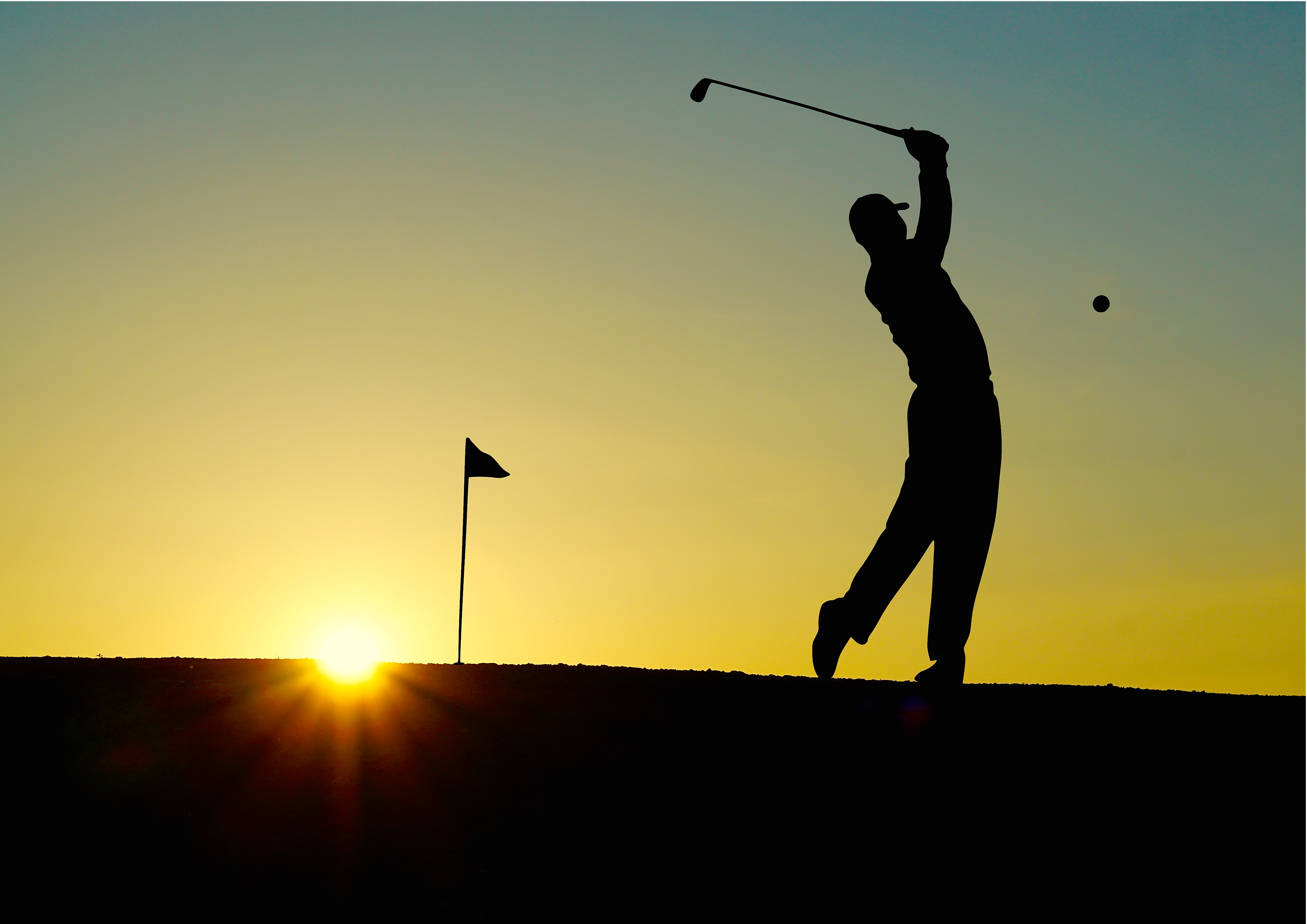 Silhouette of man playing golf during sunset photo