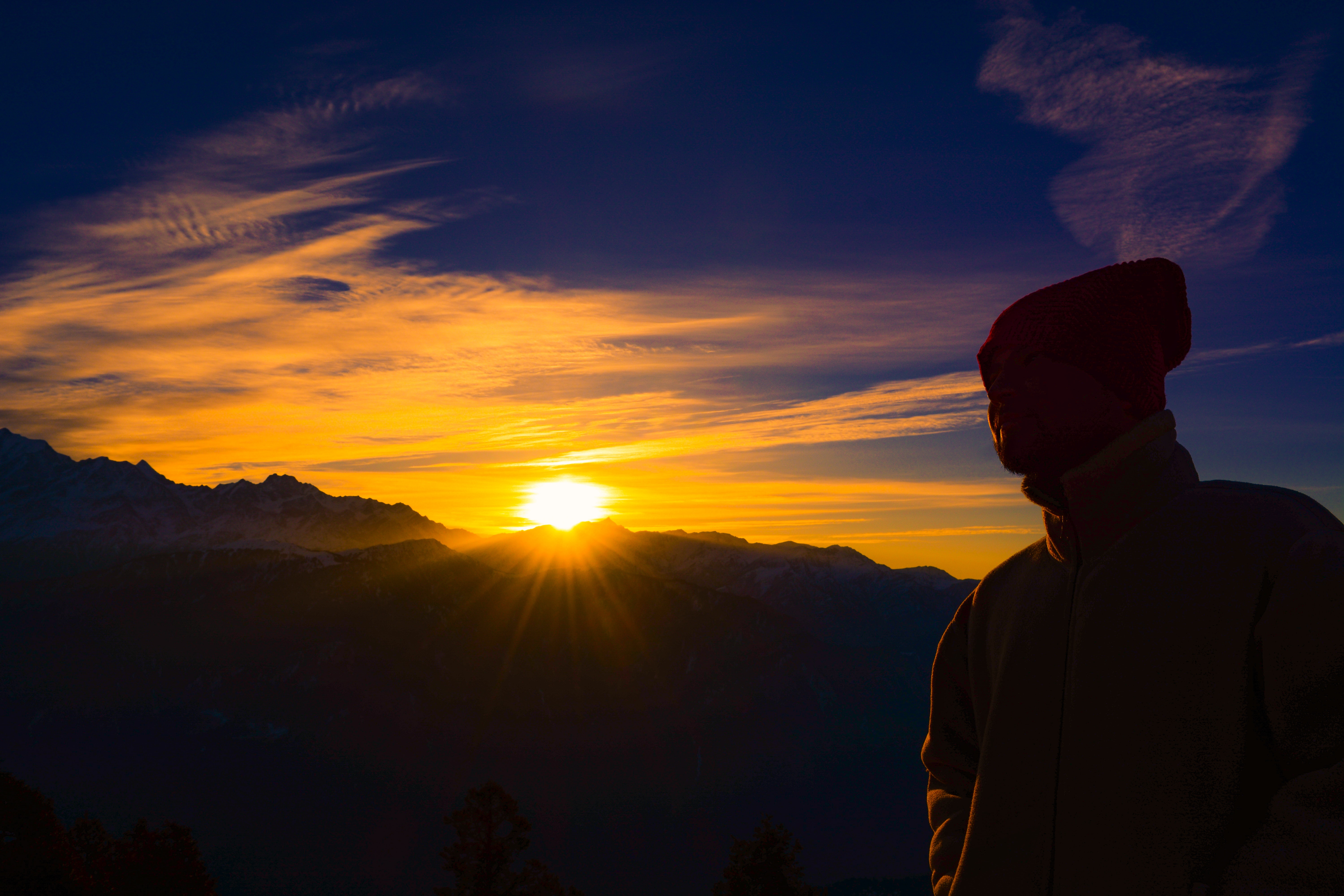 Silhouette of person near mountain during golden hour photo
