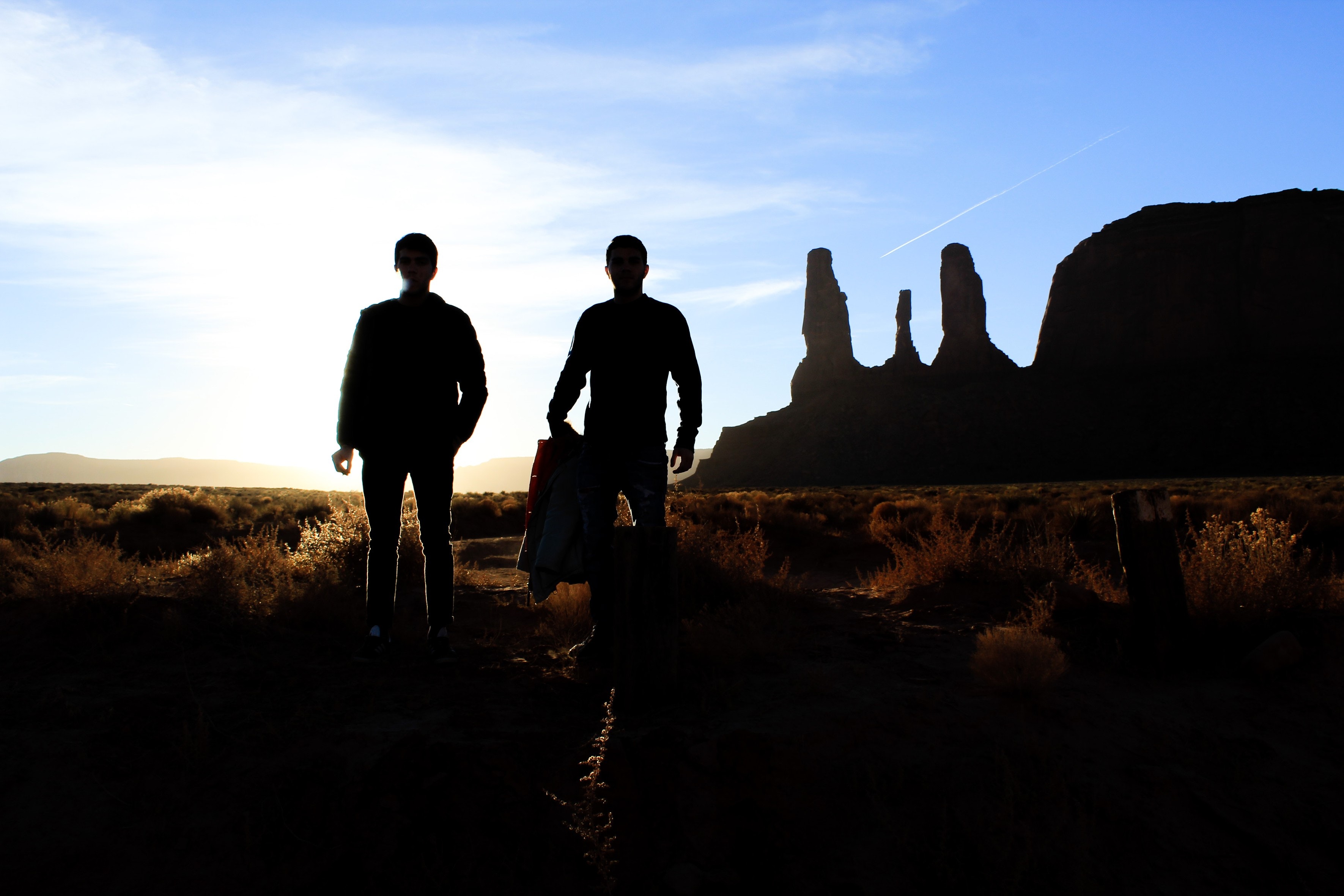 Silhouette of two person standing on the desert photo