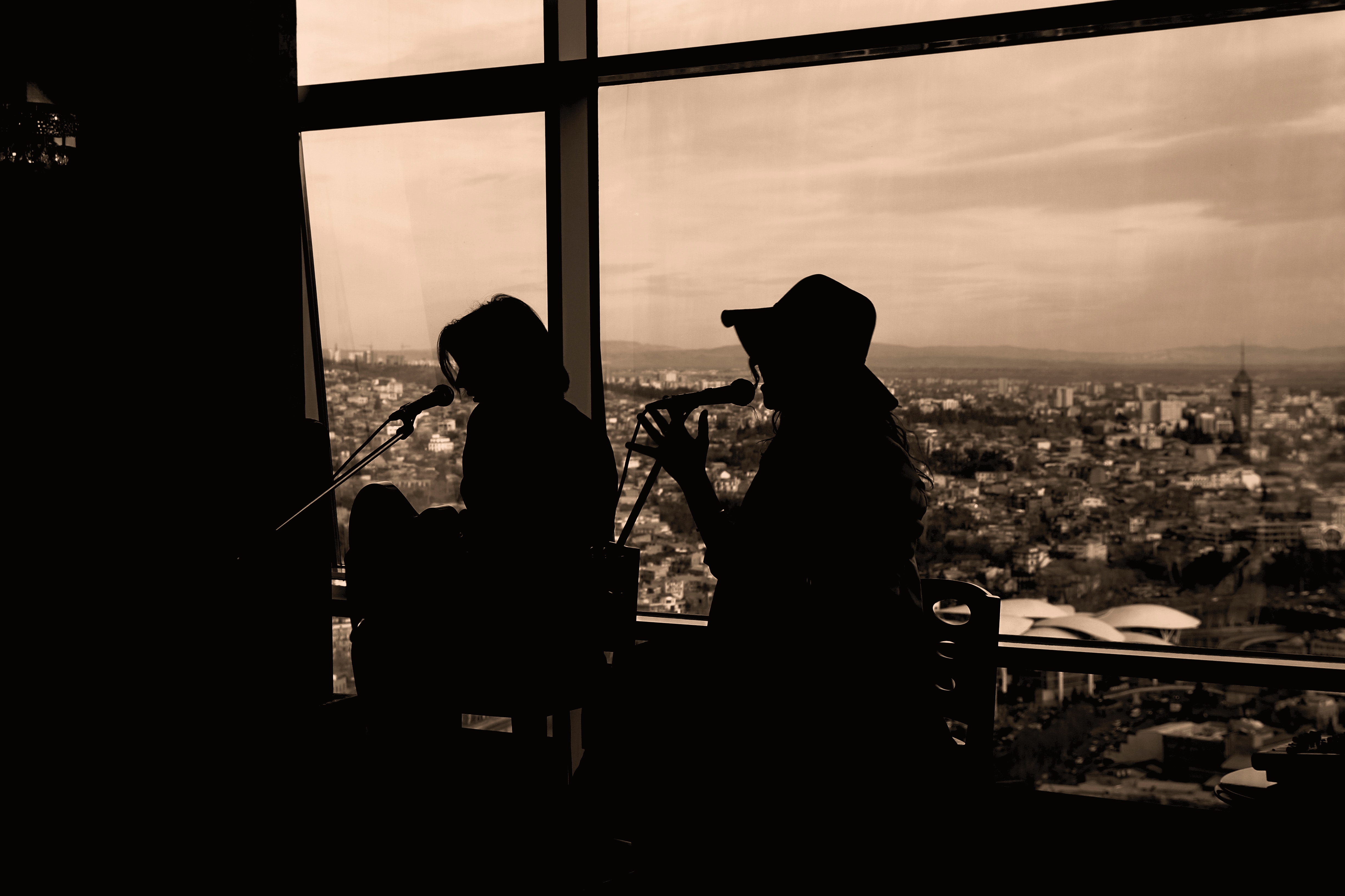 Silhouette of two women singing in sepia photography