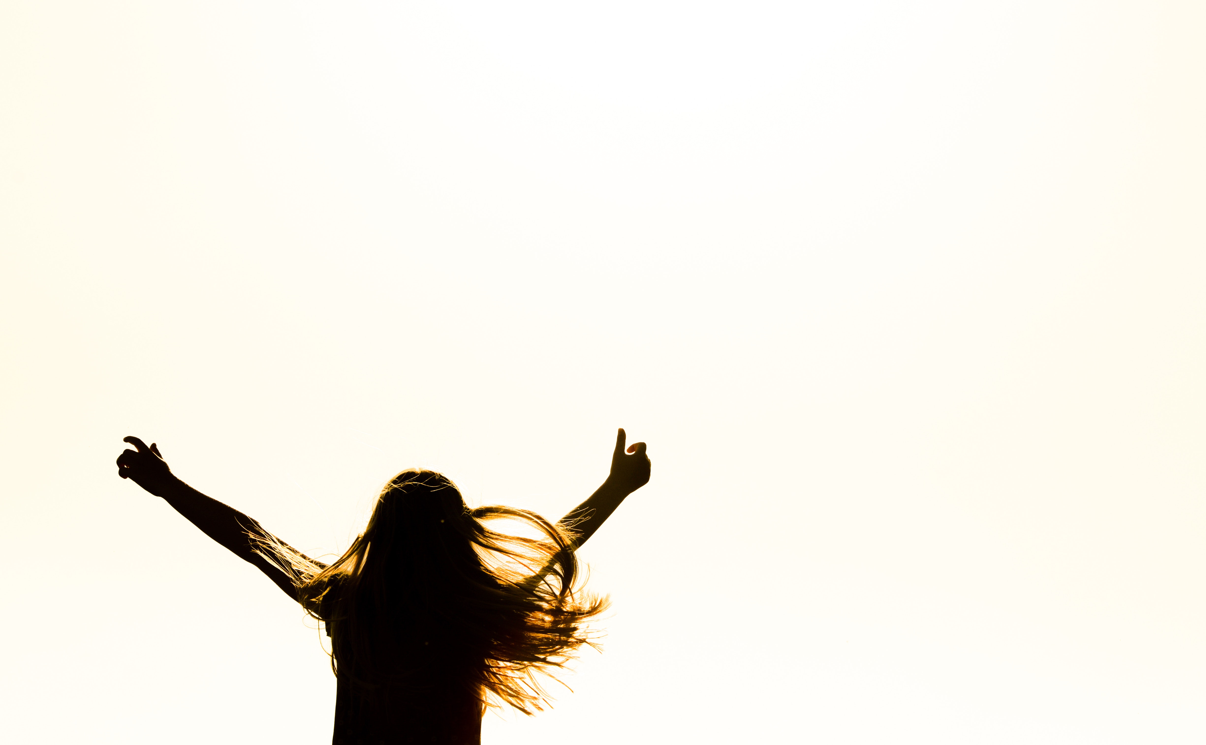 Silhouette of woman raising her hands photo