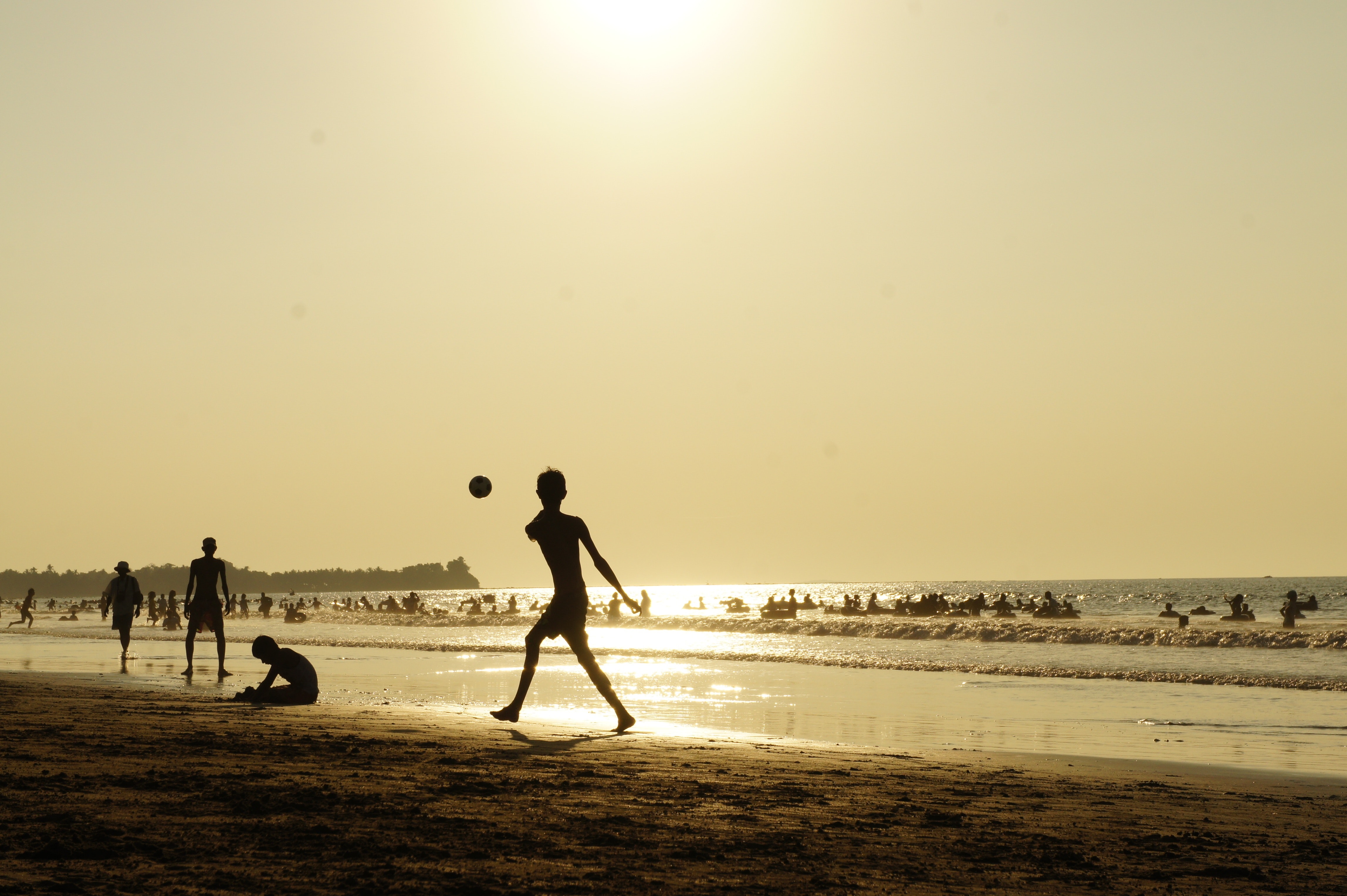 Silluhette of man playing ball near the seashore photo