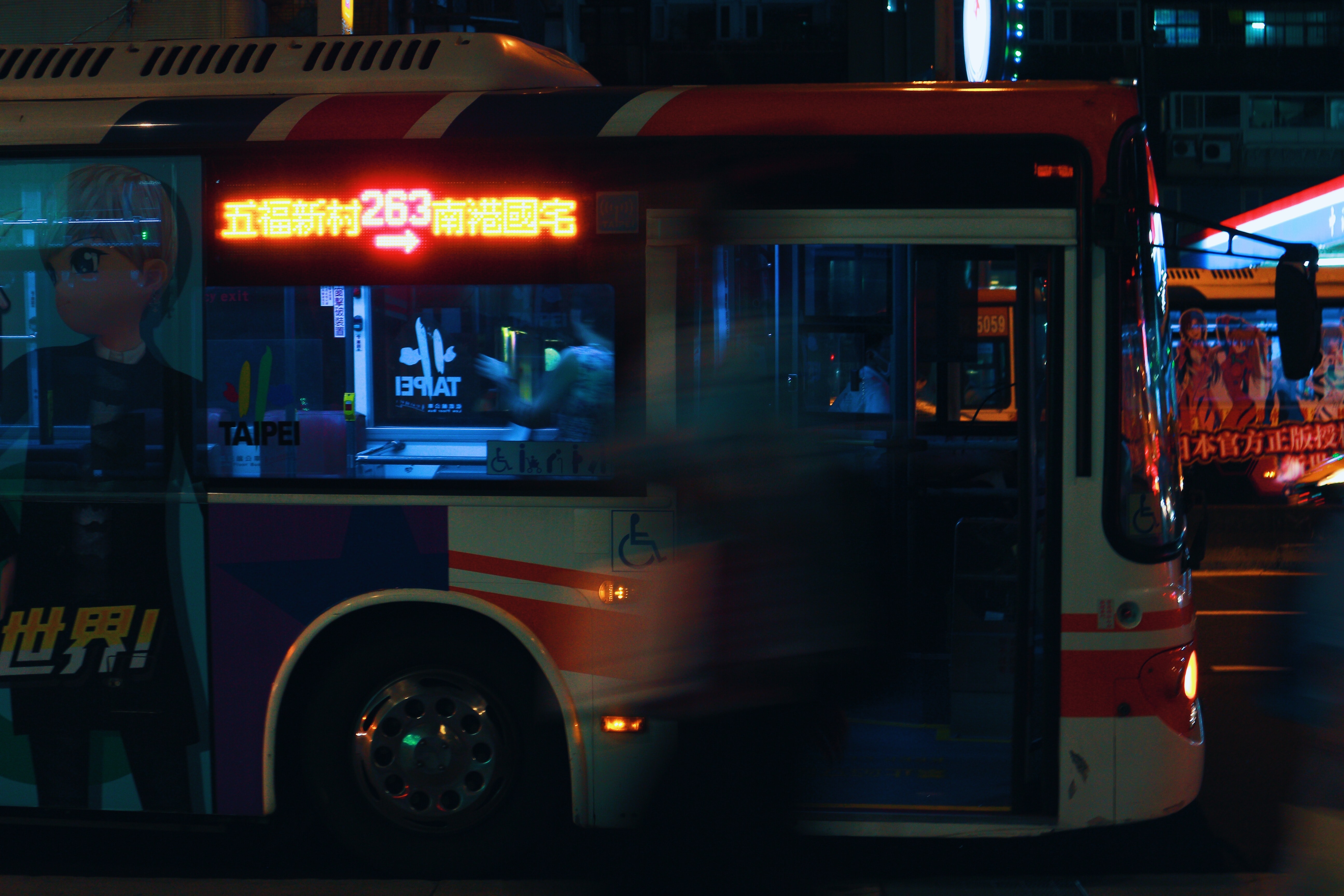 Silver city bus on a city street at night photo