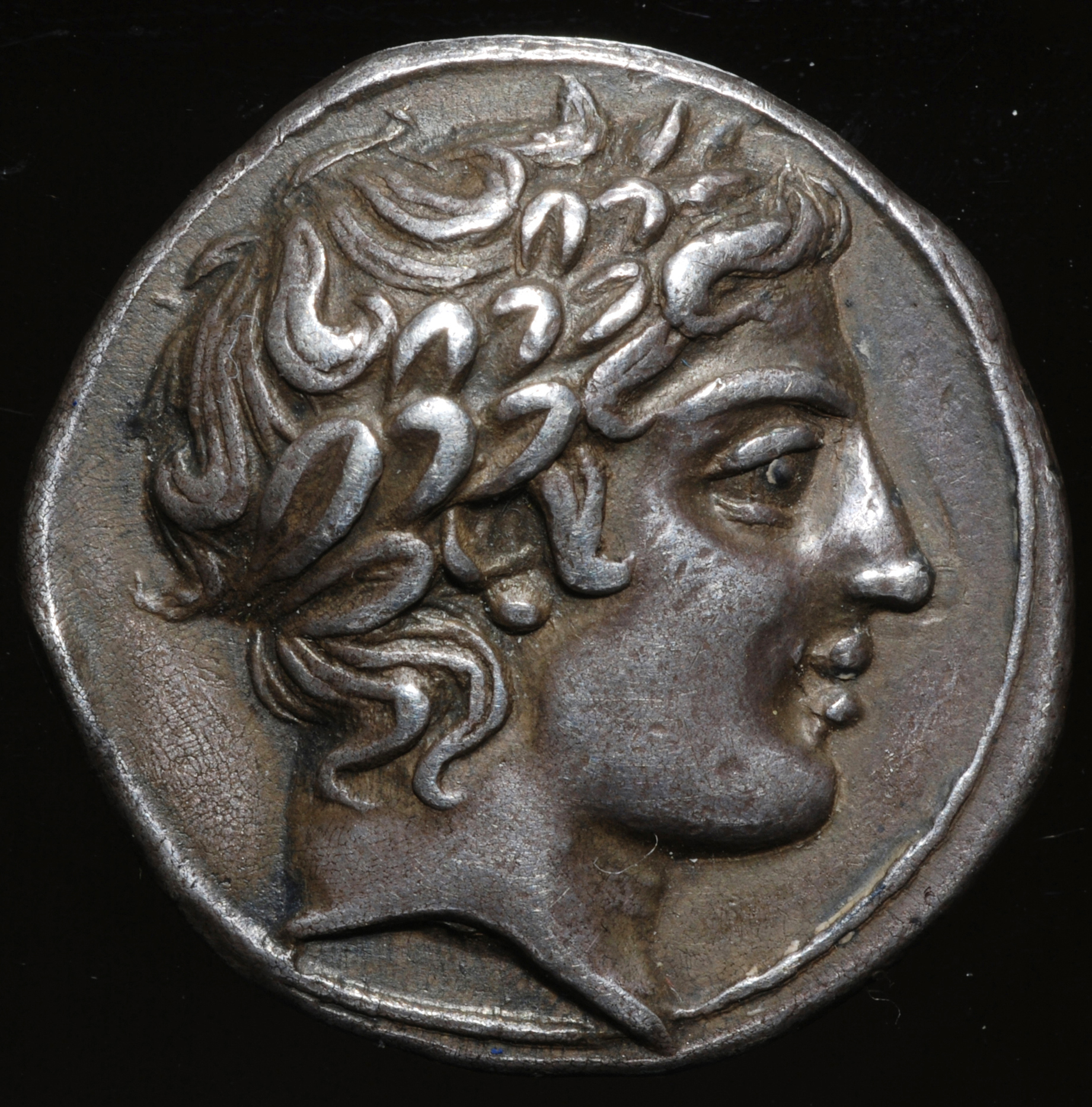 Head of Apollo on a silver coin of the IV century BC from the ...