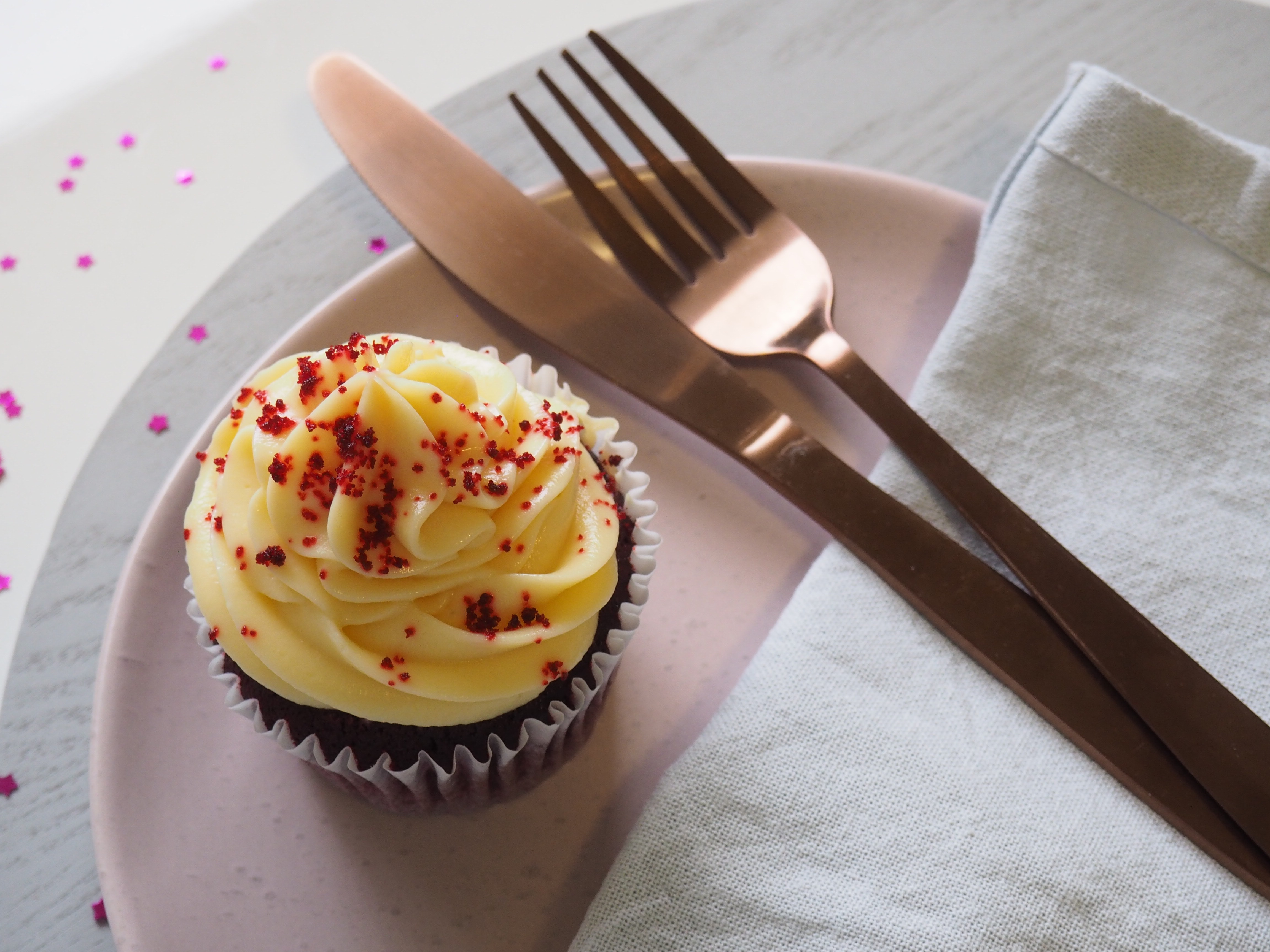 Silver fork and knife on round plate with cupcake photo